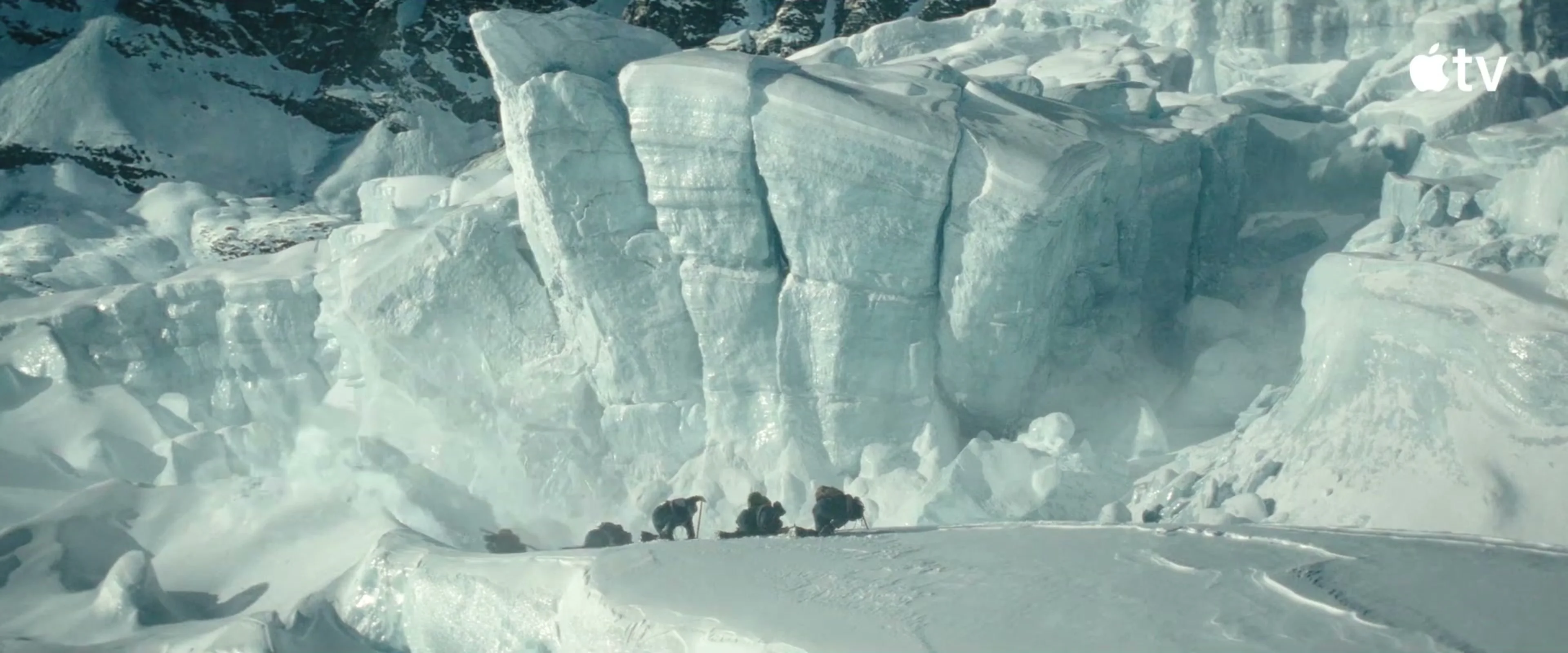 Climbers cross beneath a huge wall of ice in Tenzing.