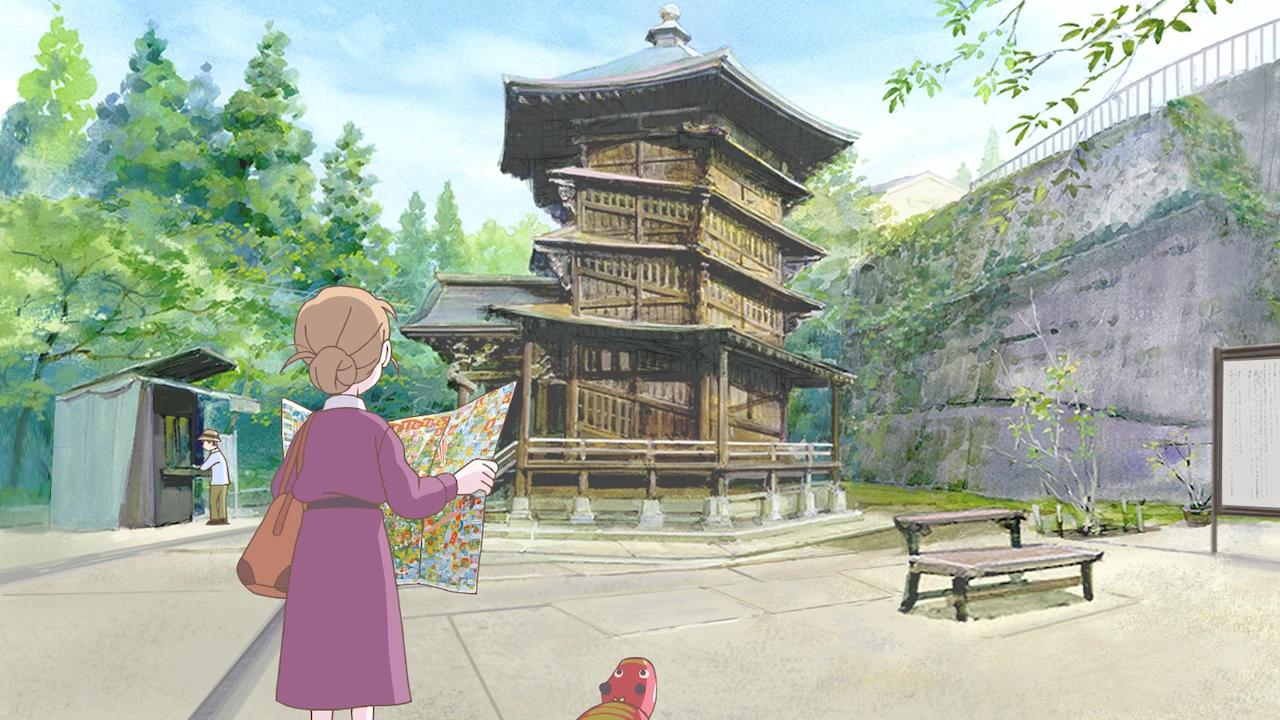 Sophie stands near a traditional wooden building.