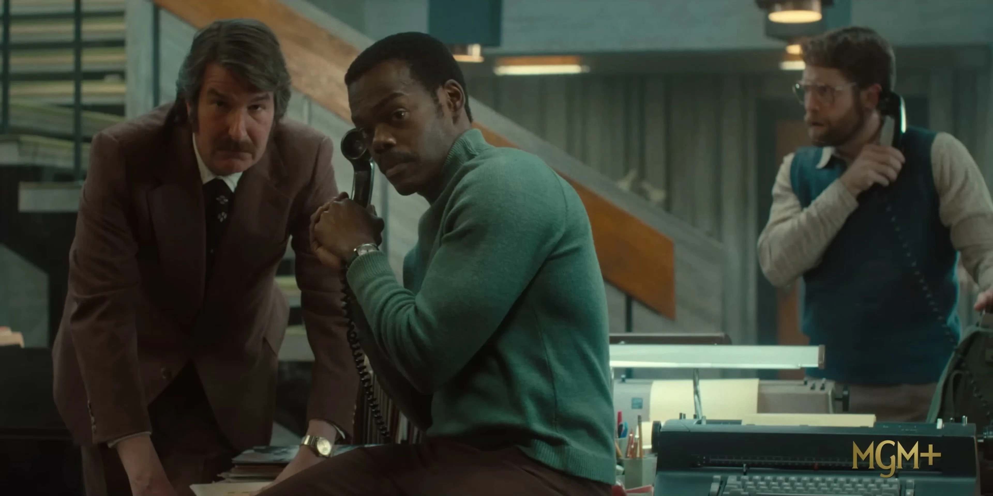 Three newsroom staff members react to a telephone call in American Hostage.