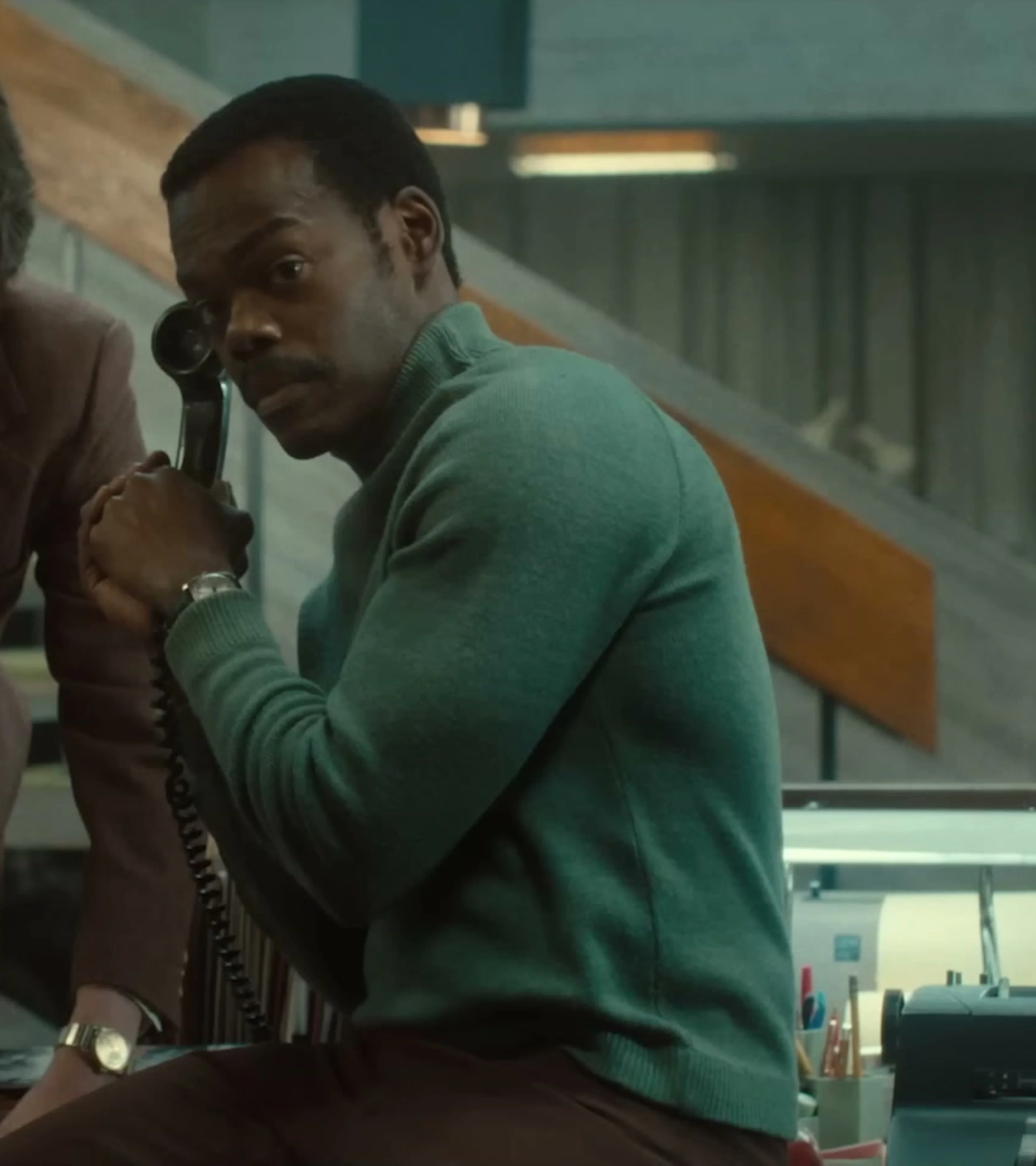 Three newsroom staff members react to a telephone call in American Hostage.