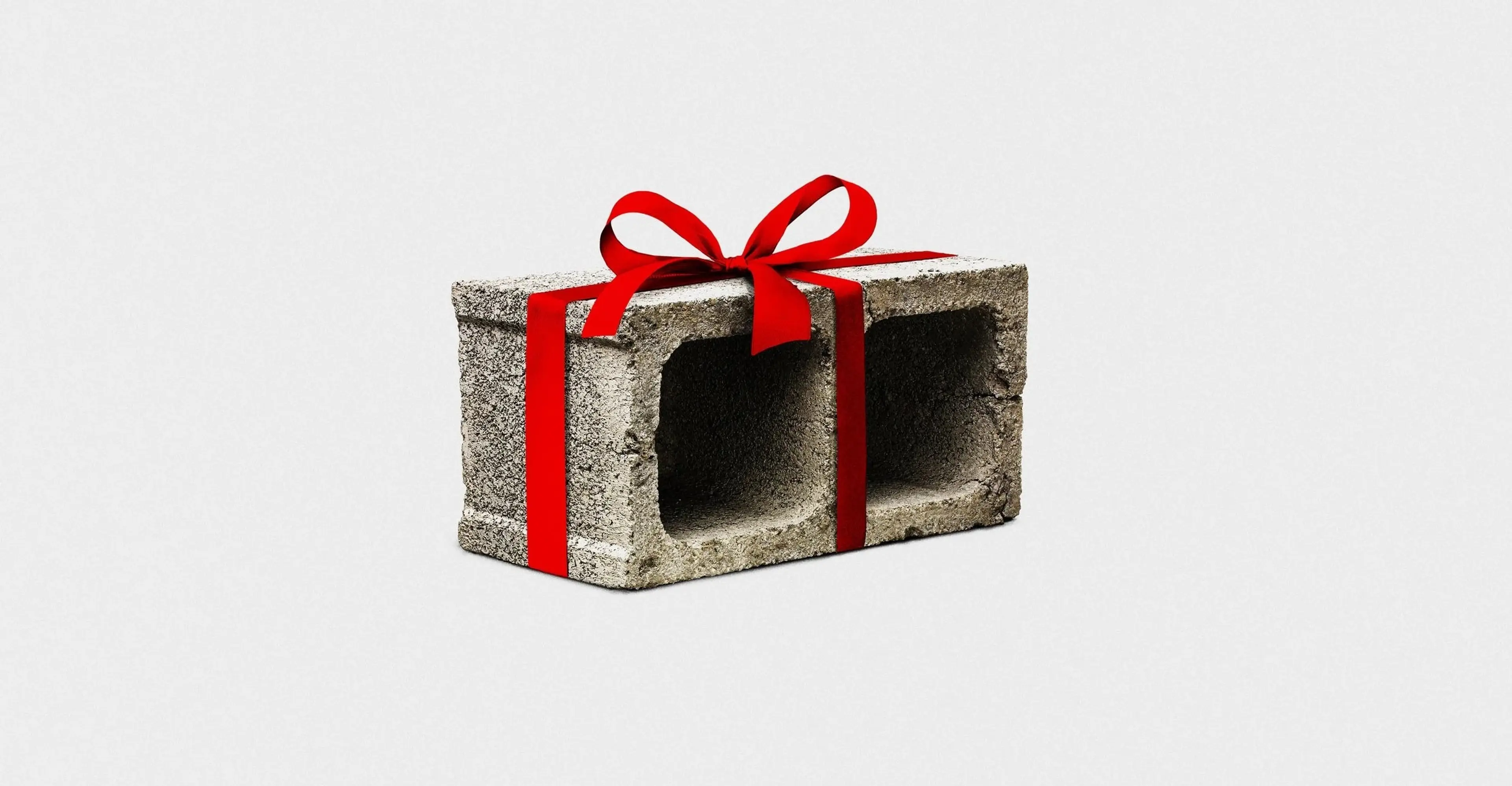 A concrete block tied with a red ribbon on a clean white background.