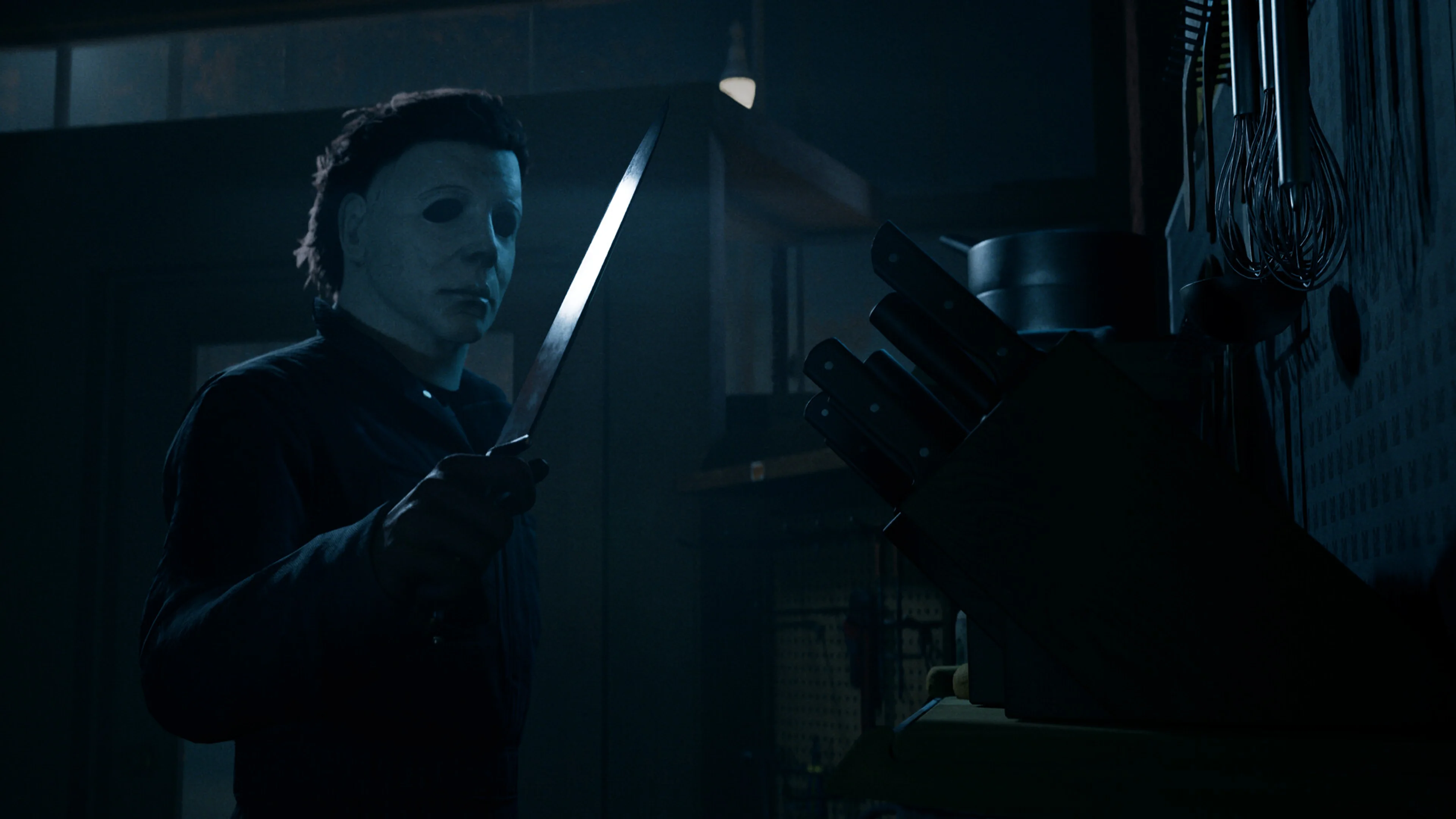 Michael Myers holds a kitchen knife beside a knife block in Halloween: The Game.