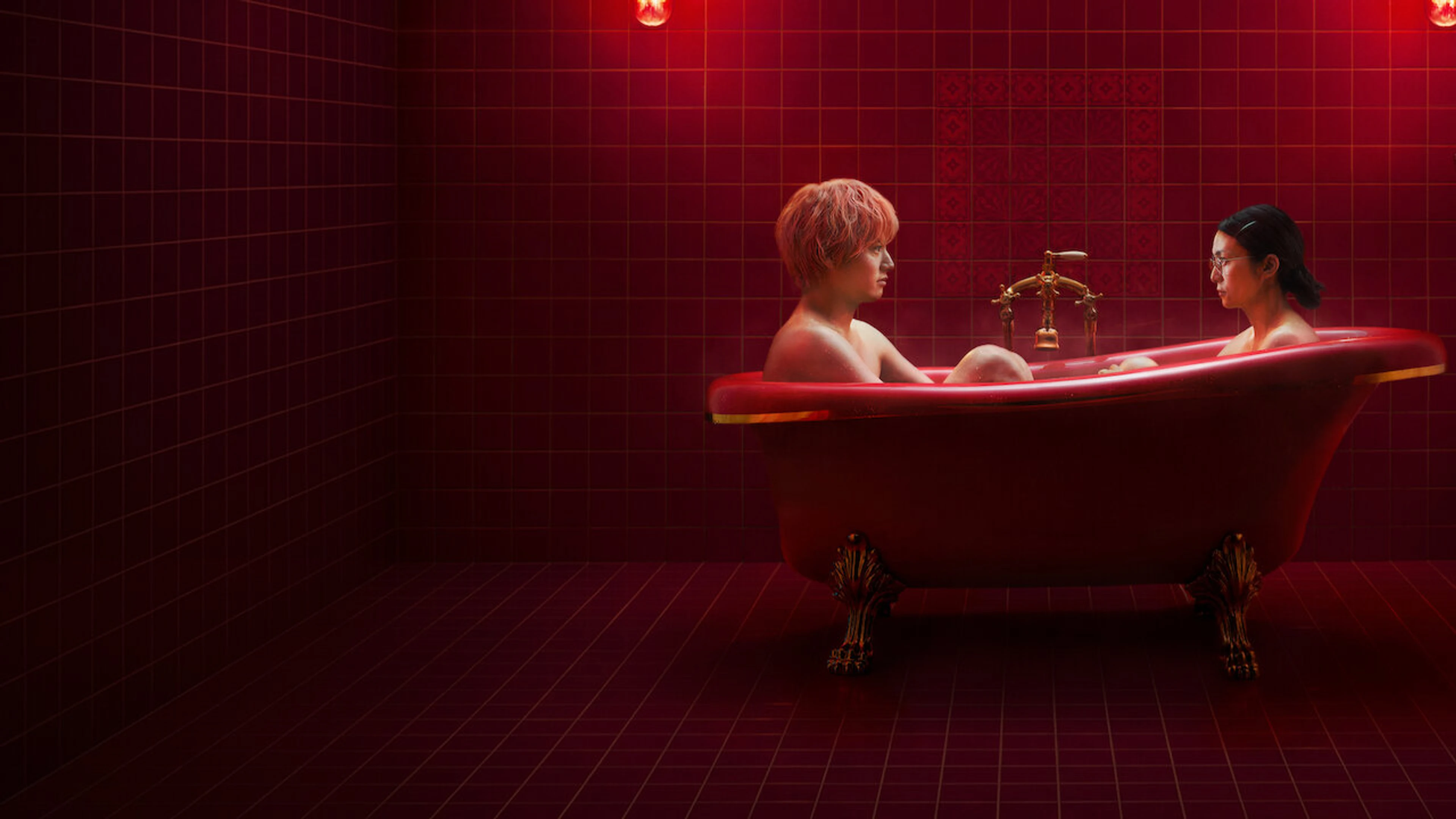 Yui and Sena face each other in a bright red bathtub.