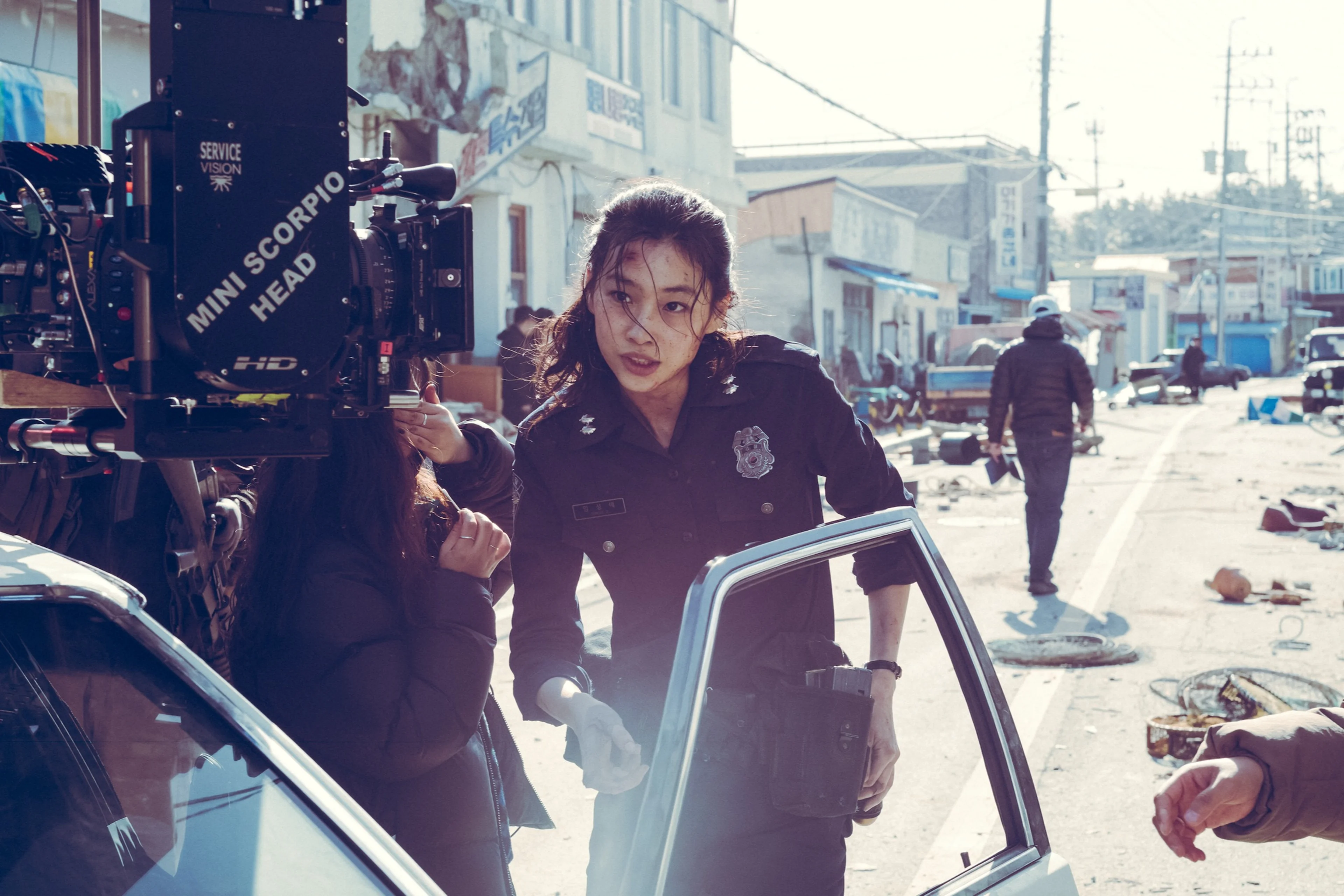 Hoyeon as officer Sung-ae stands on the Hope set beside a motion-picture camera.