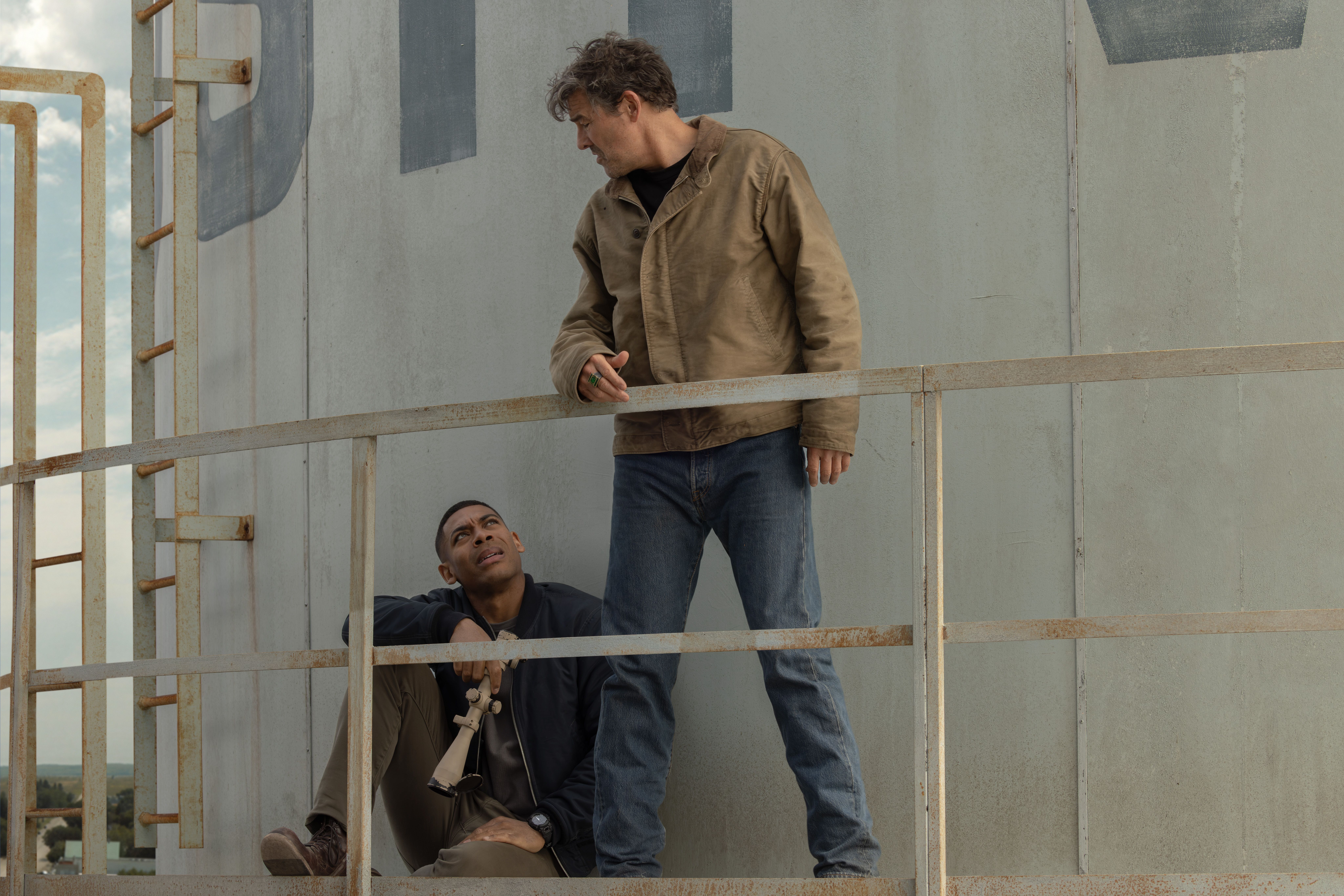 Kyle Chandler as Hal Jordan stands above Aaron Pierre as John Stewart at a tower in Lanterns.