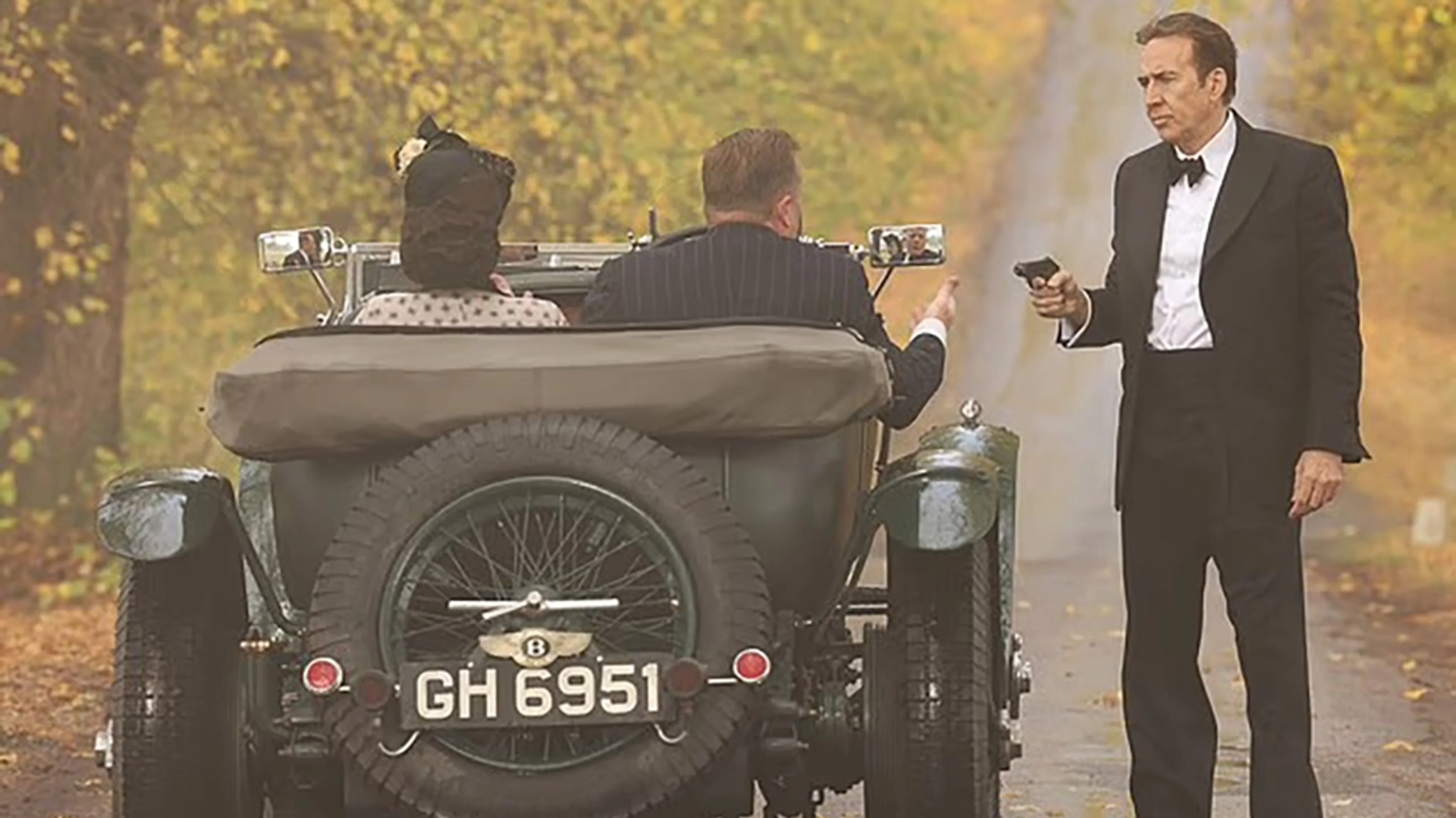 Nicolas Cage stands beside a vintage car while filming Fortitude.