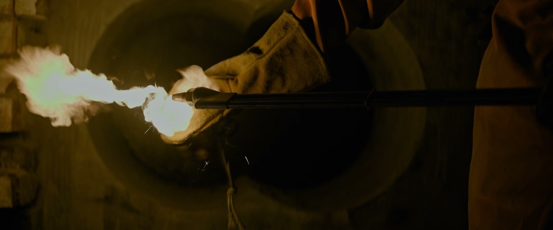 Gloved hands hold a lit cutting torch during the robbery in Fuze.