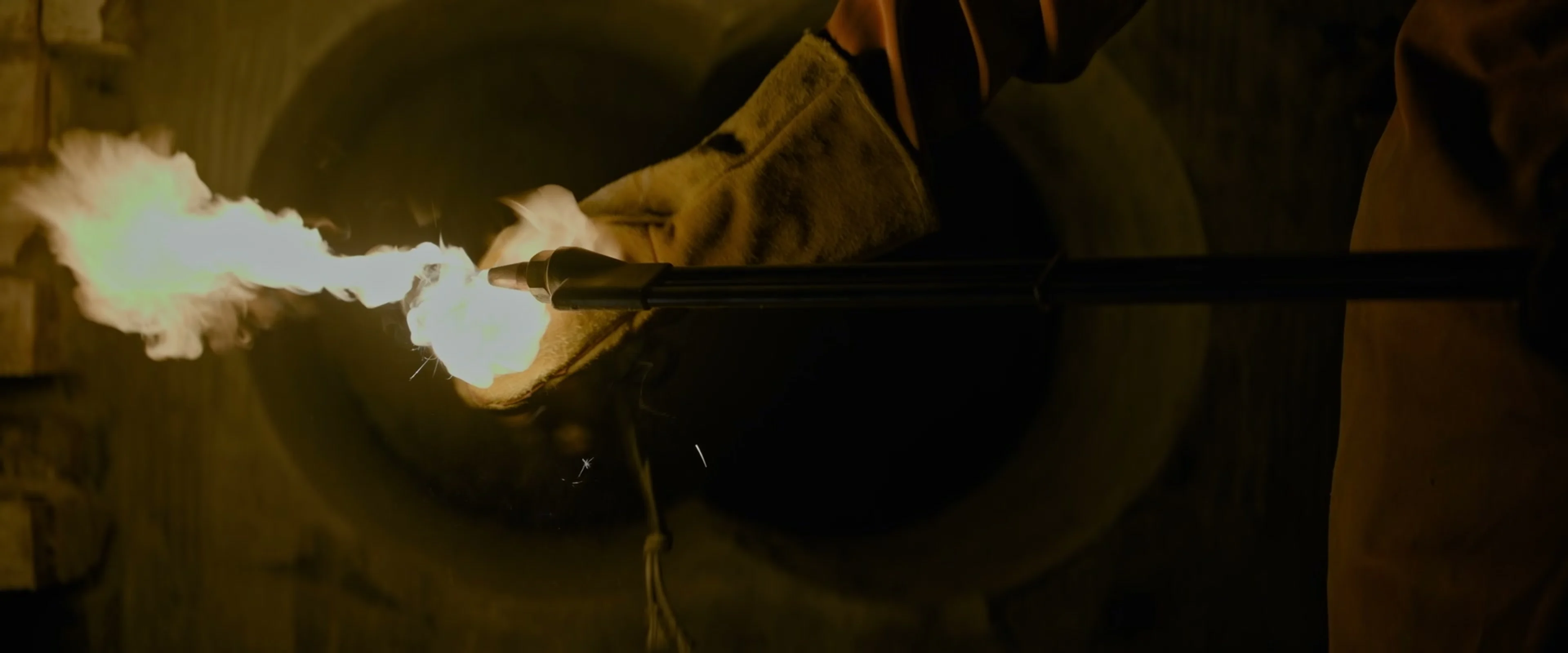 Gloved hands hold a lit cutting torch during the robbery in Fuze.