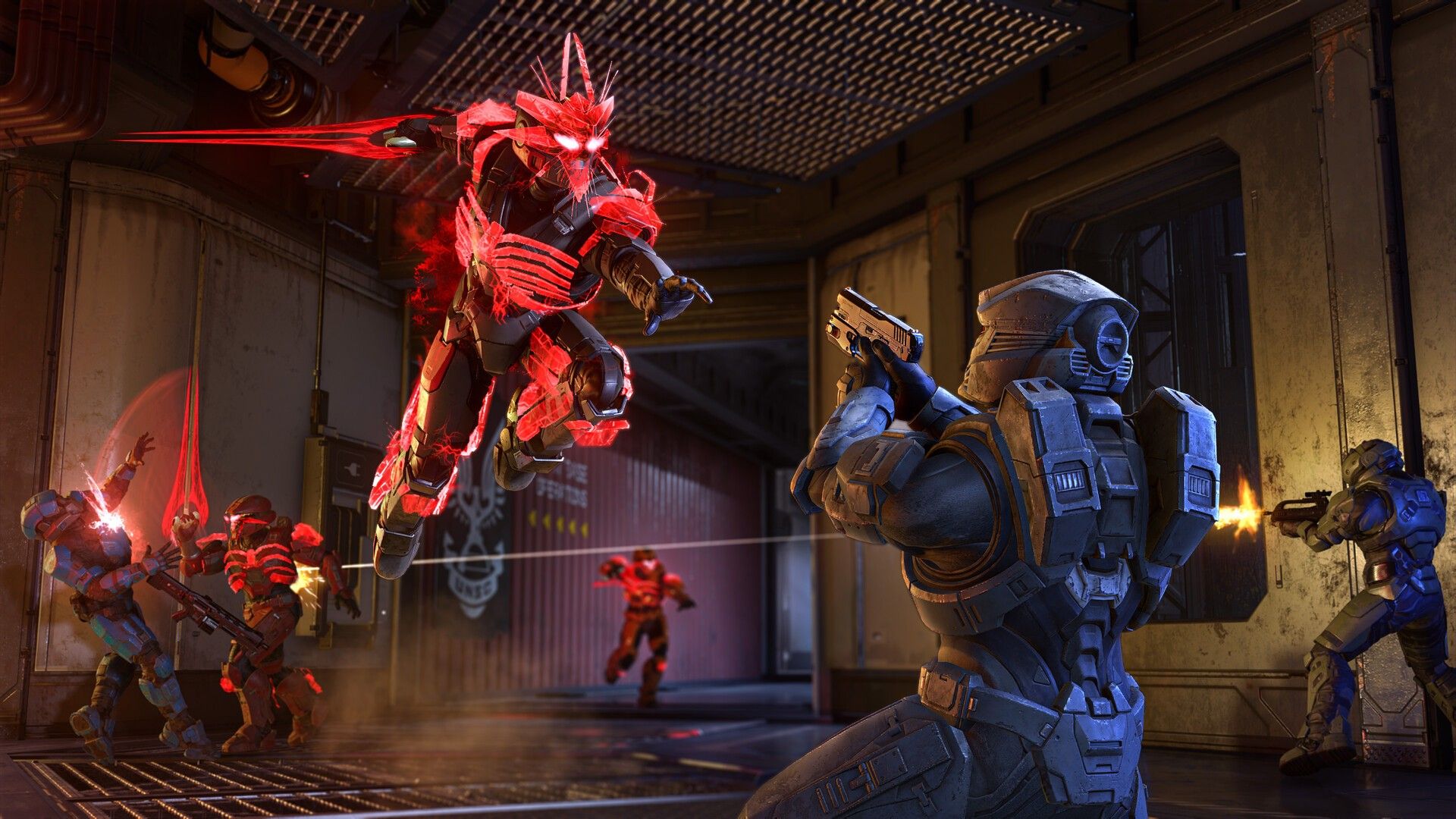 A Spartan fires at red-armored enemies in a multiplayer battle.