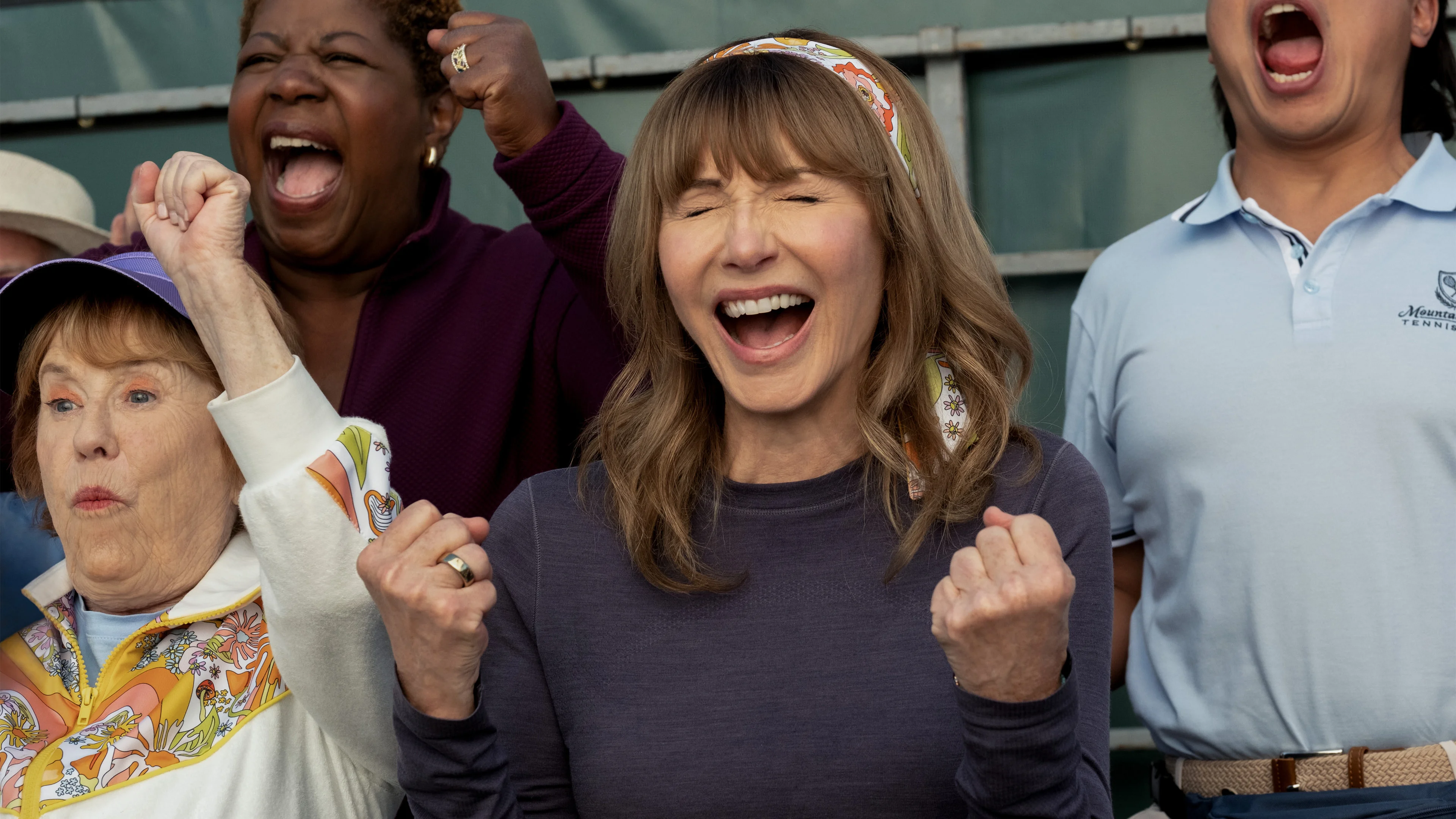 Mary Steenburgen as Candace cheers beside other spectators.