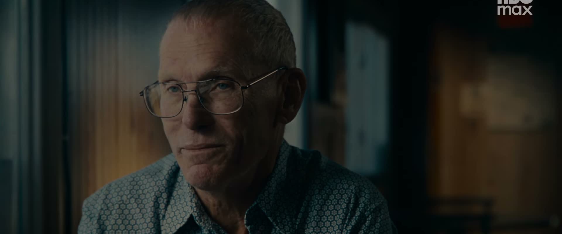 A man wearing glasses sits for an interview in the documentary.