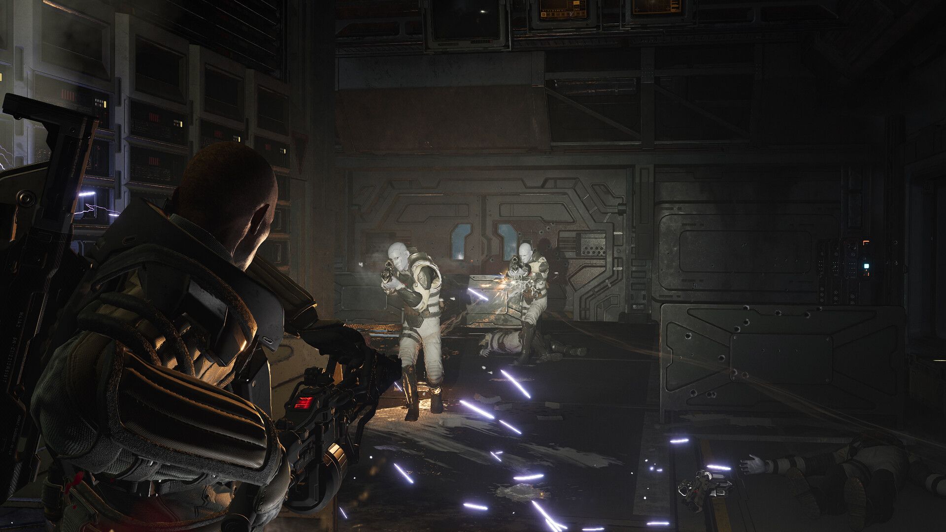 A marine faces synthetic enemies in a dark room.
