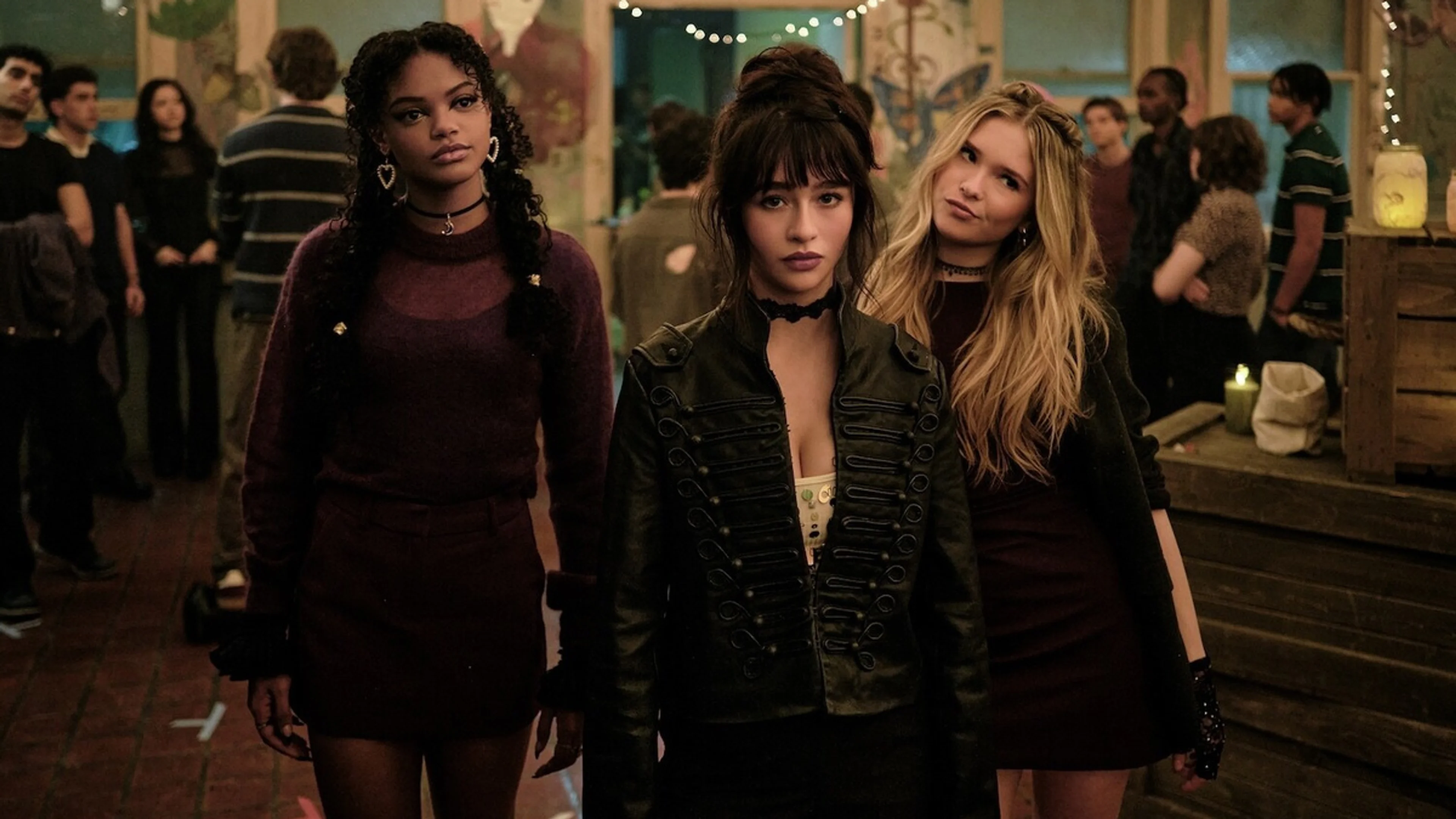 Three Coven Academy students stand together at a crowded school gathering.