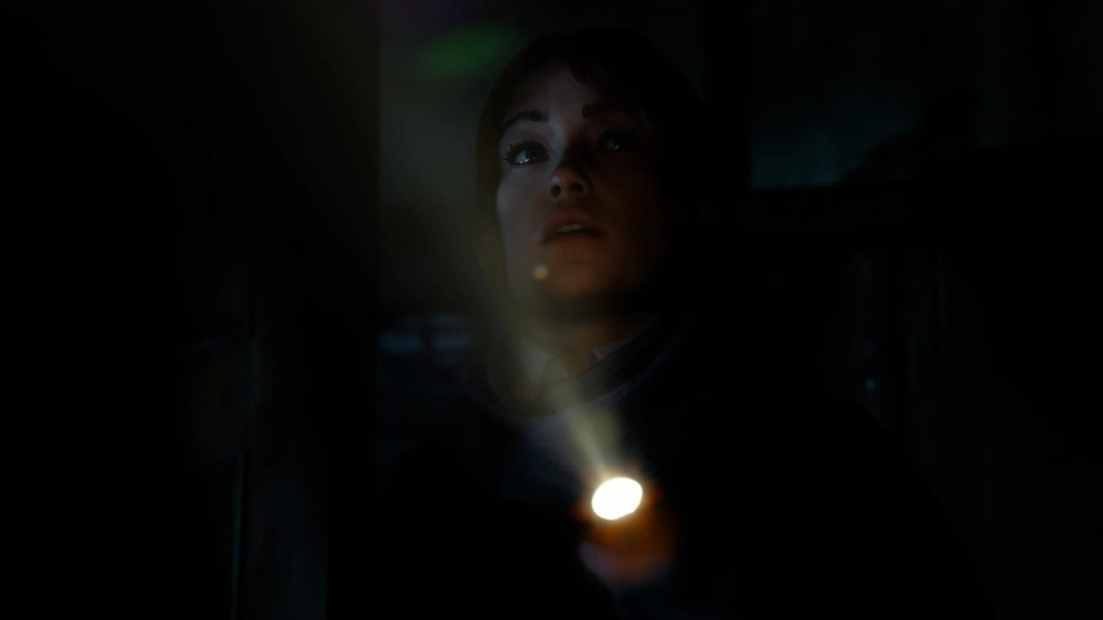 A member of Dead True searches a dark interior with a flashlight in Until Dawn 2.
