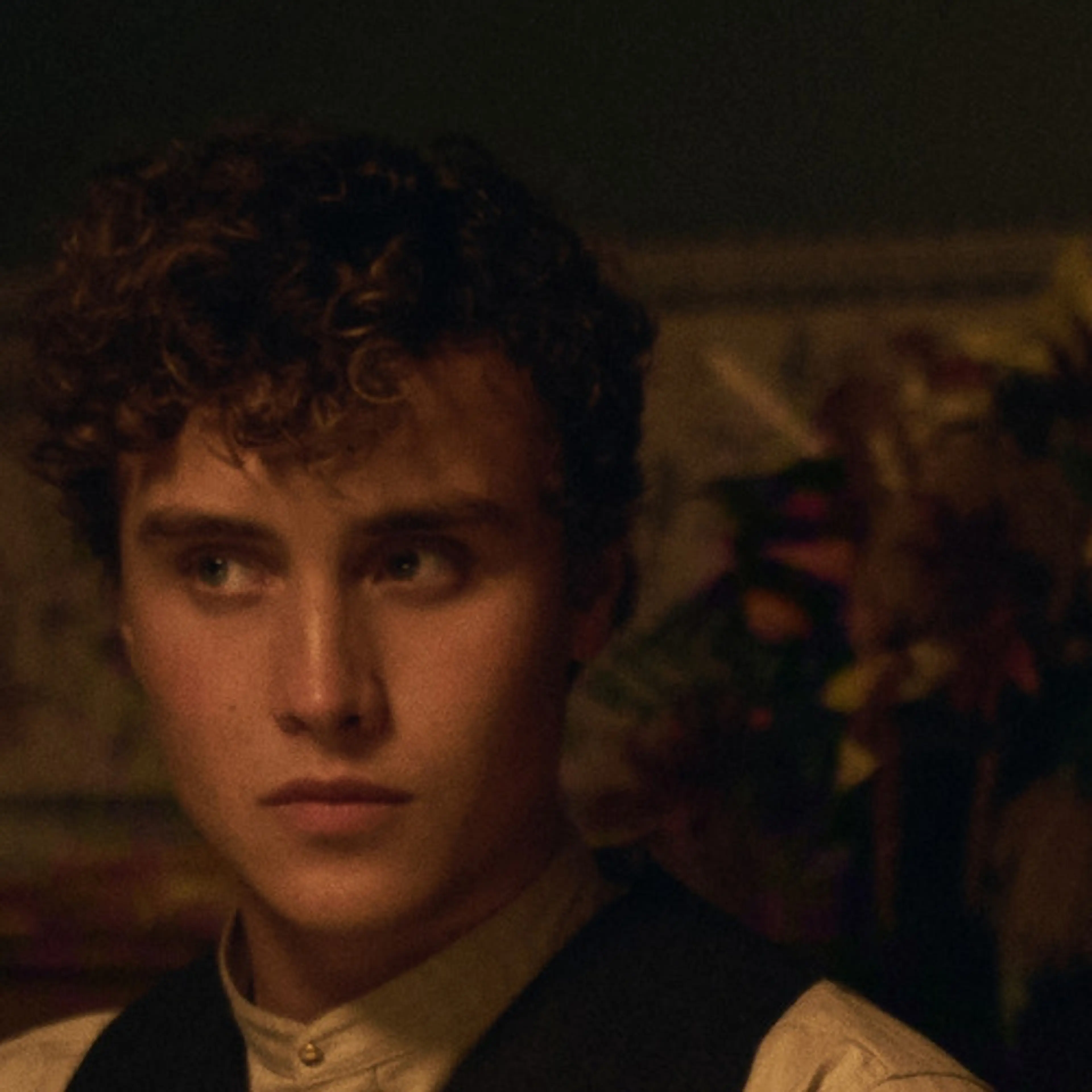 Joseph Zada as Cal Trask, seated at a candlelit table in East of Eden.