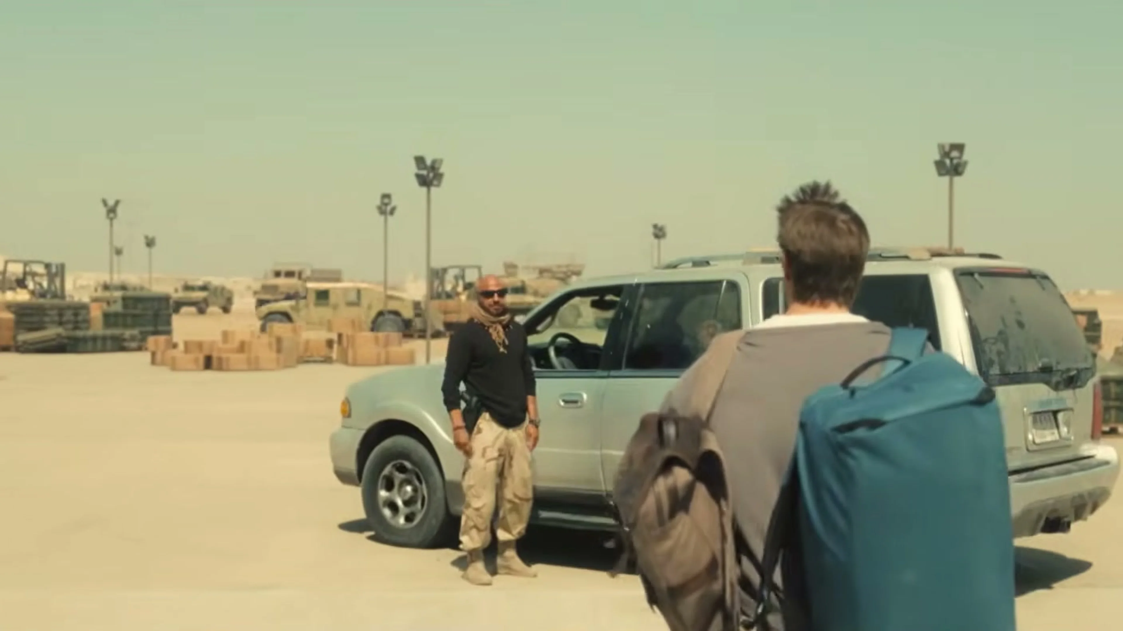 Joel Kinnaman as John Nixon walks across a dusty military base in High Value Target.