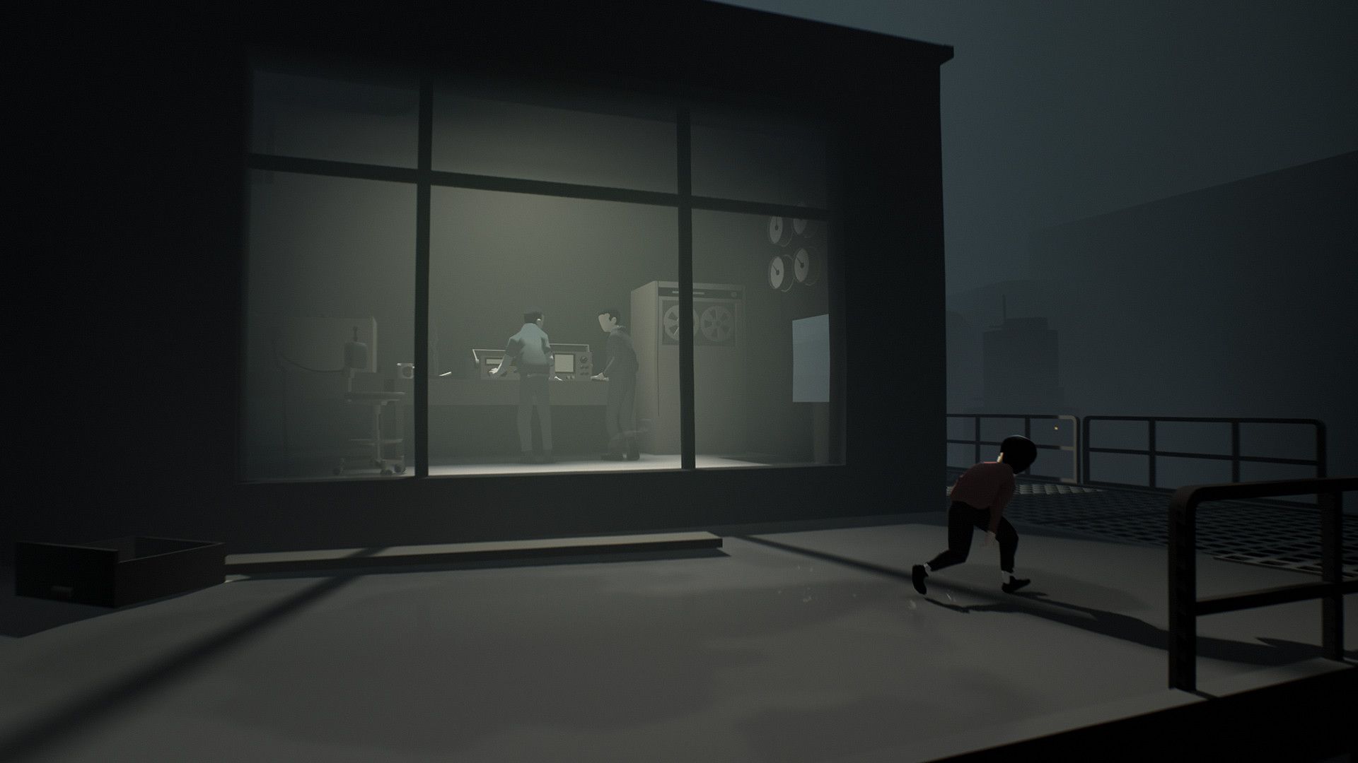 The boy passes a glass room in a dim industrial building.