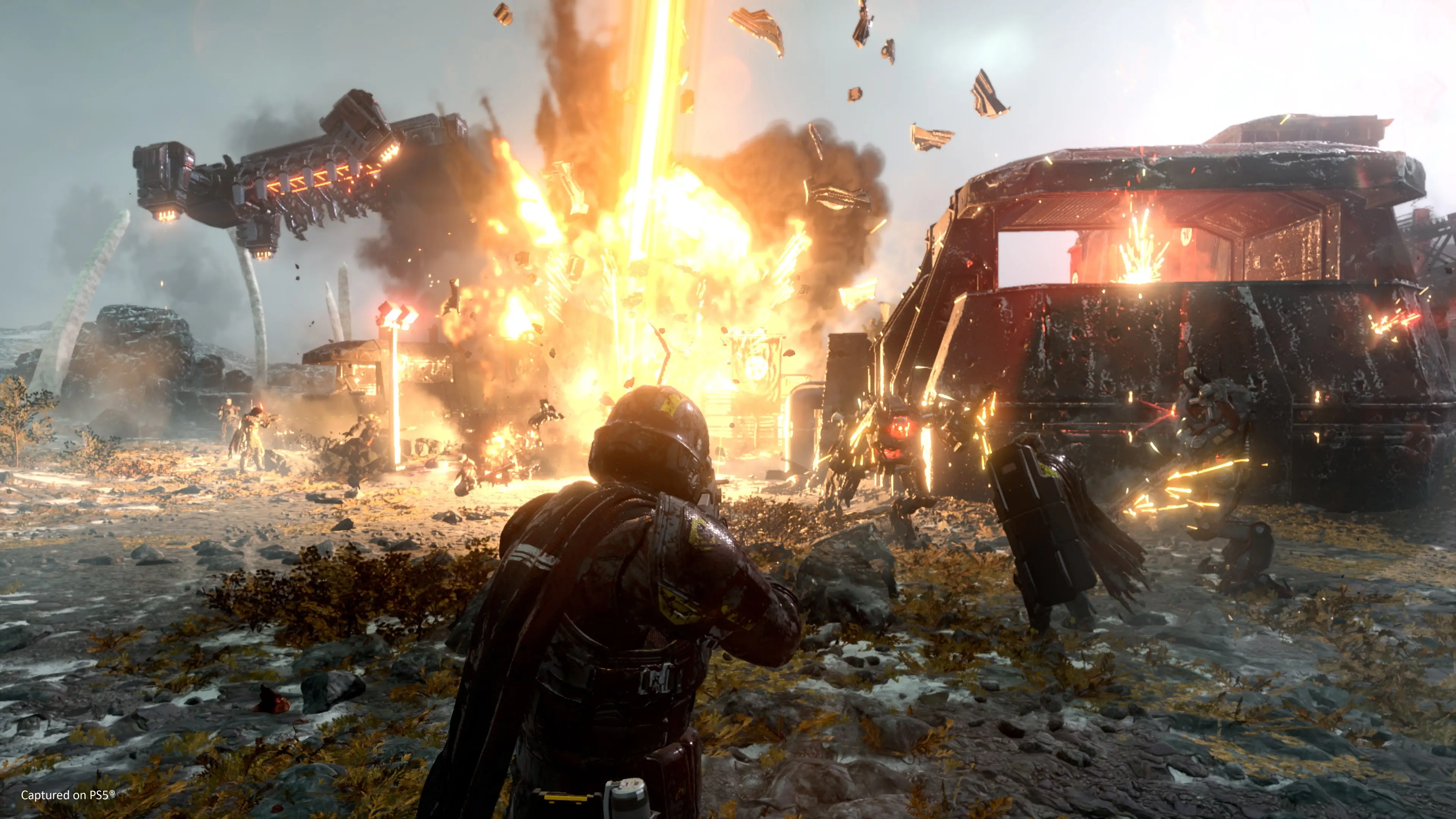Helldivers advance as a bright Stratagem strike destroys an Automaton installation.