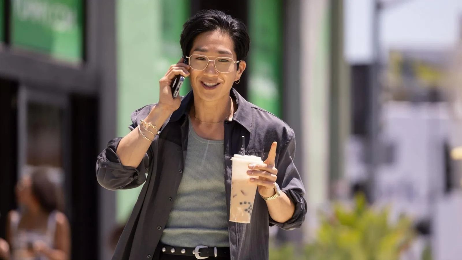 Tim Jo as investigator Daniel Kim walks outside with a phone.