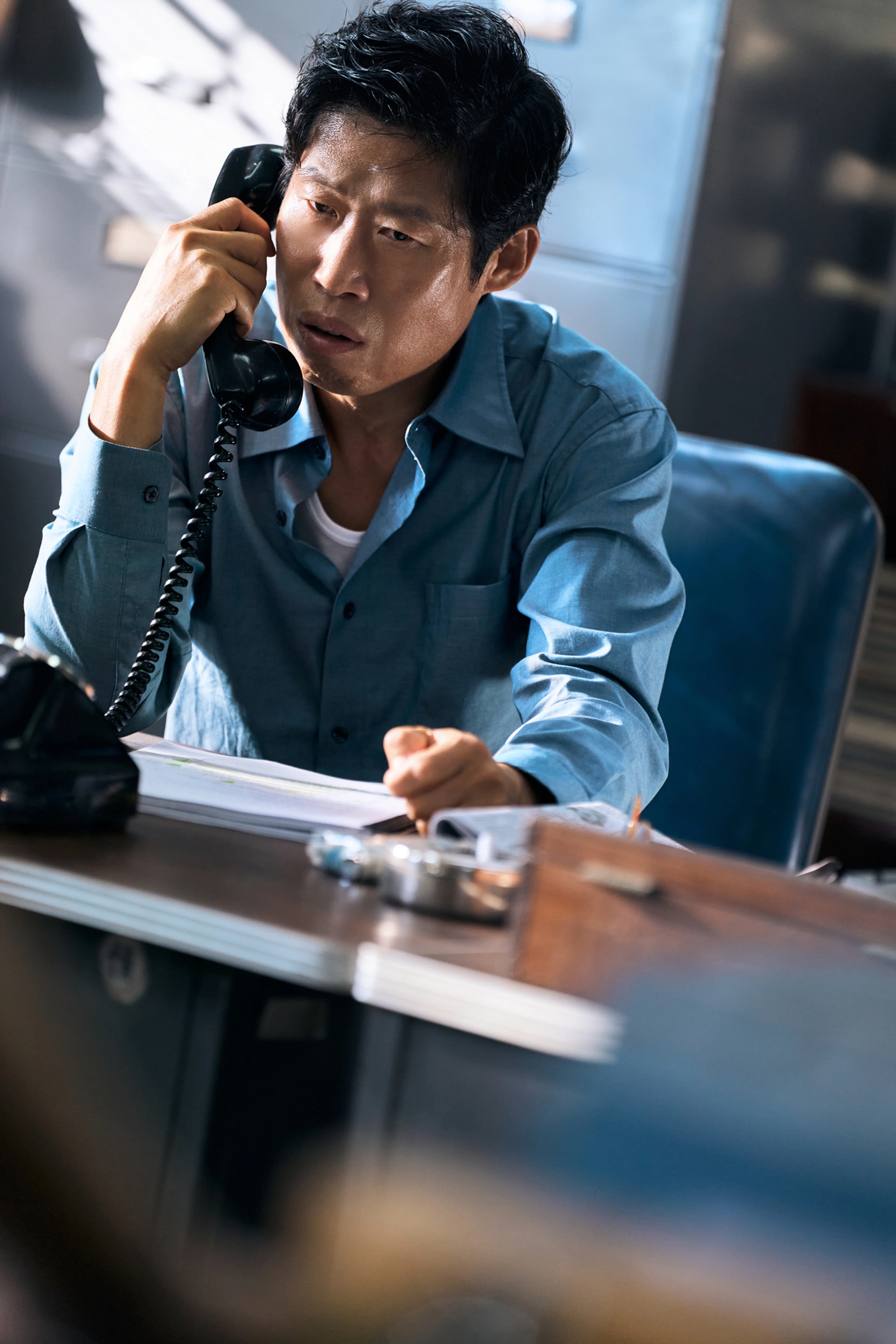 Yoo Hae-jin holds a telephone receiver in The Assassin(s).
