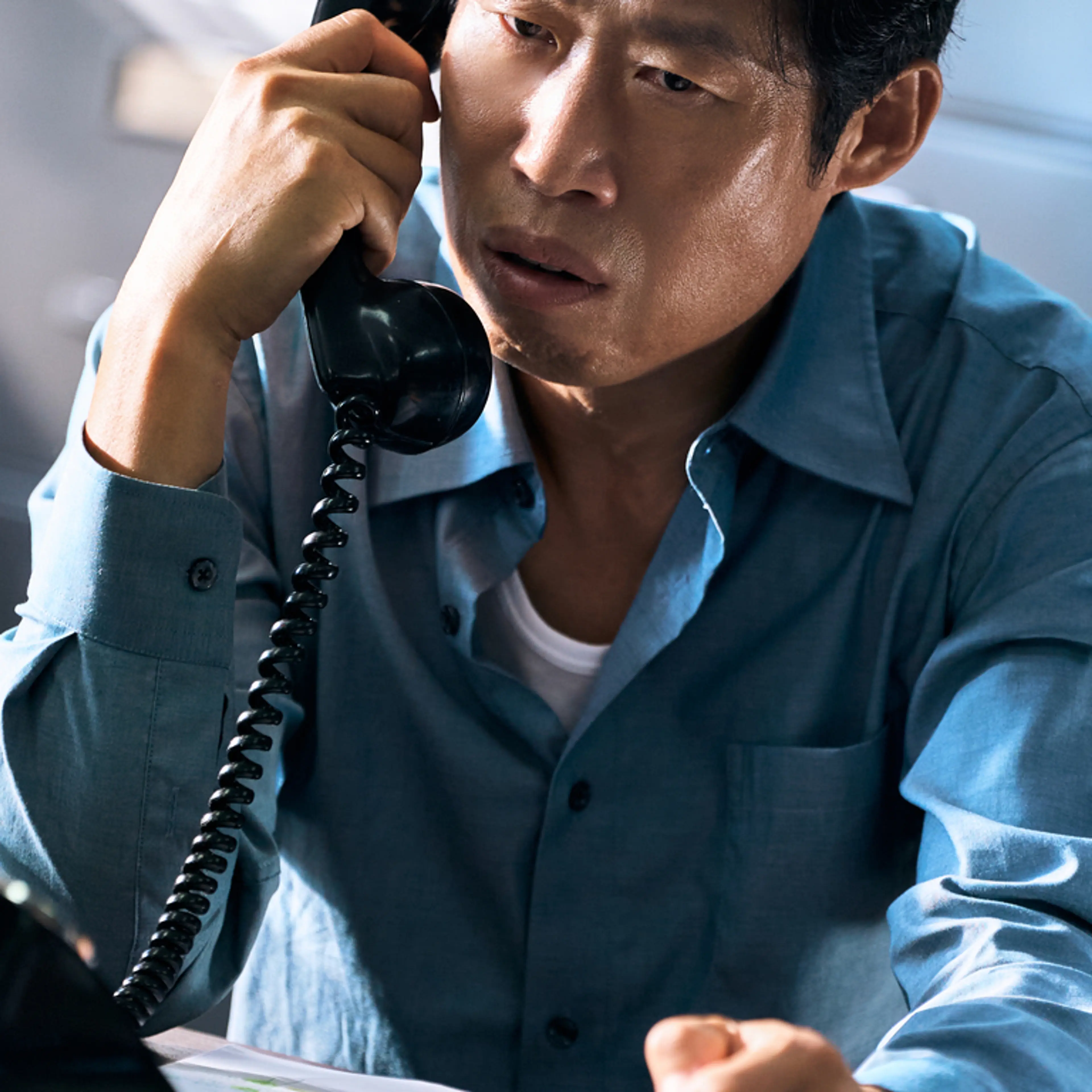 Yoo Hae-jin as Cheol-gu, holding a telephone receiver.