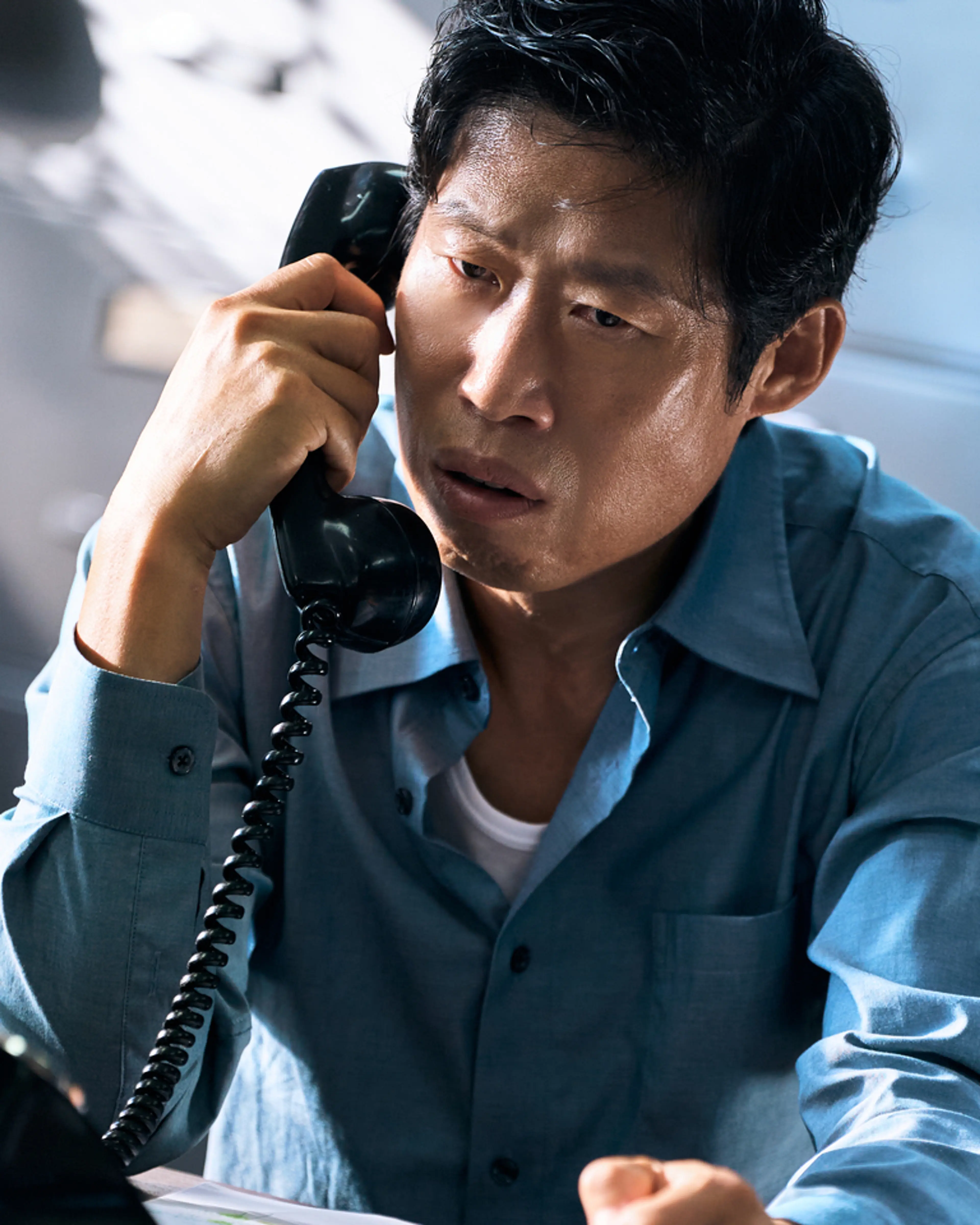 Yoo Hae-jin as Cheol-gu, holding a telephone receiver.