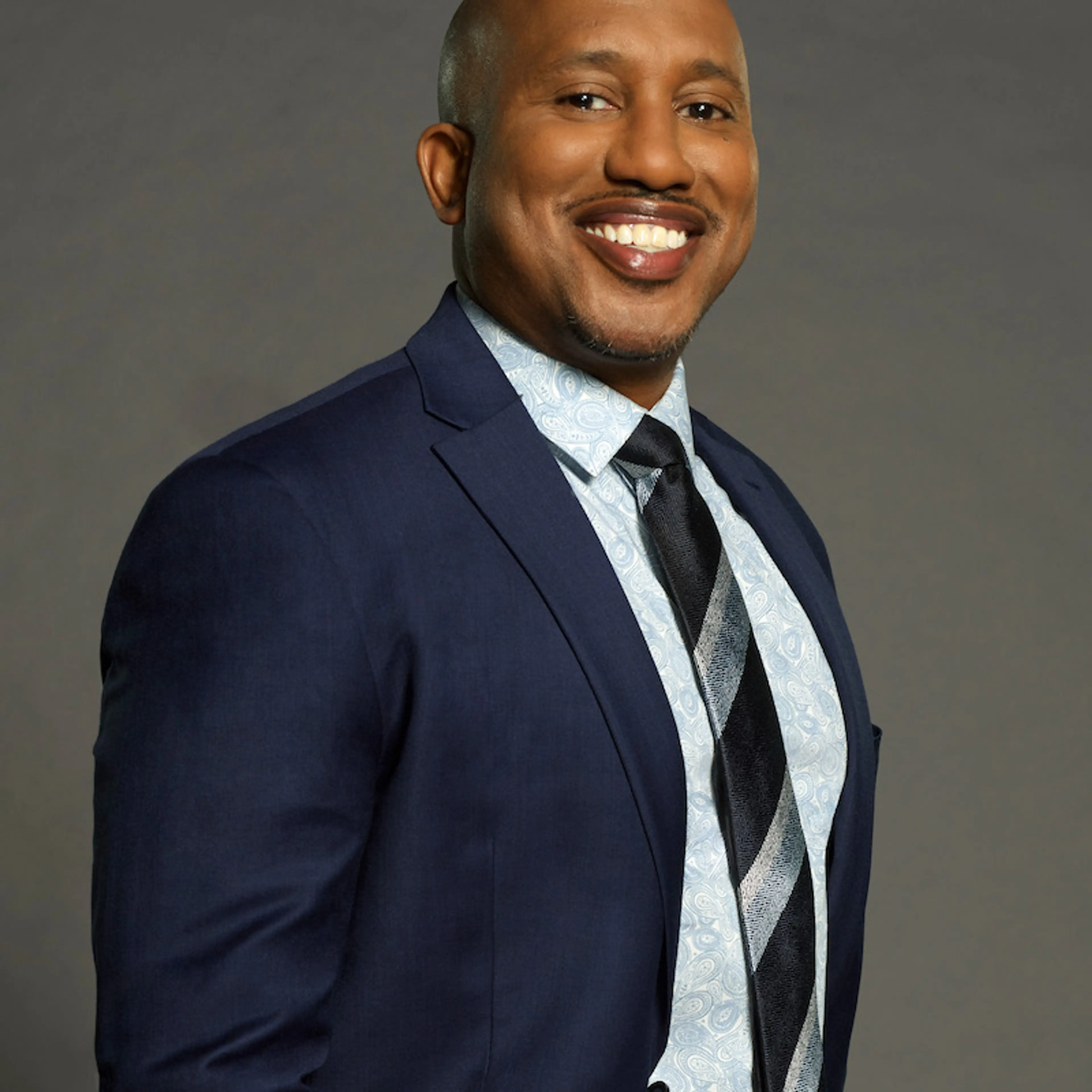 Chris Redd smiles in a blue suit for Celebrity Million Dollar Secret.