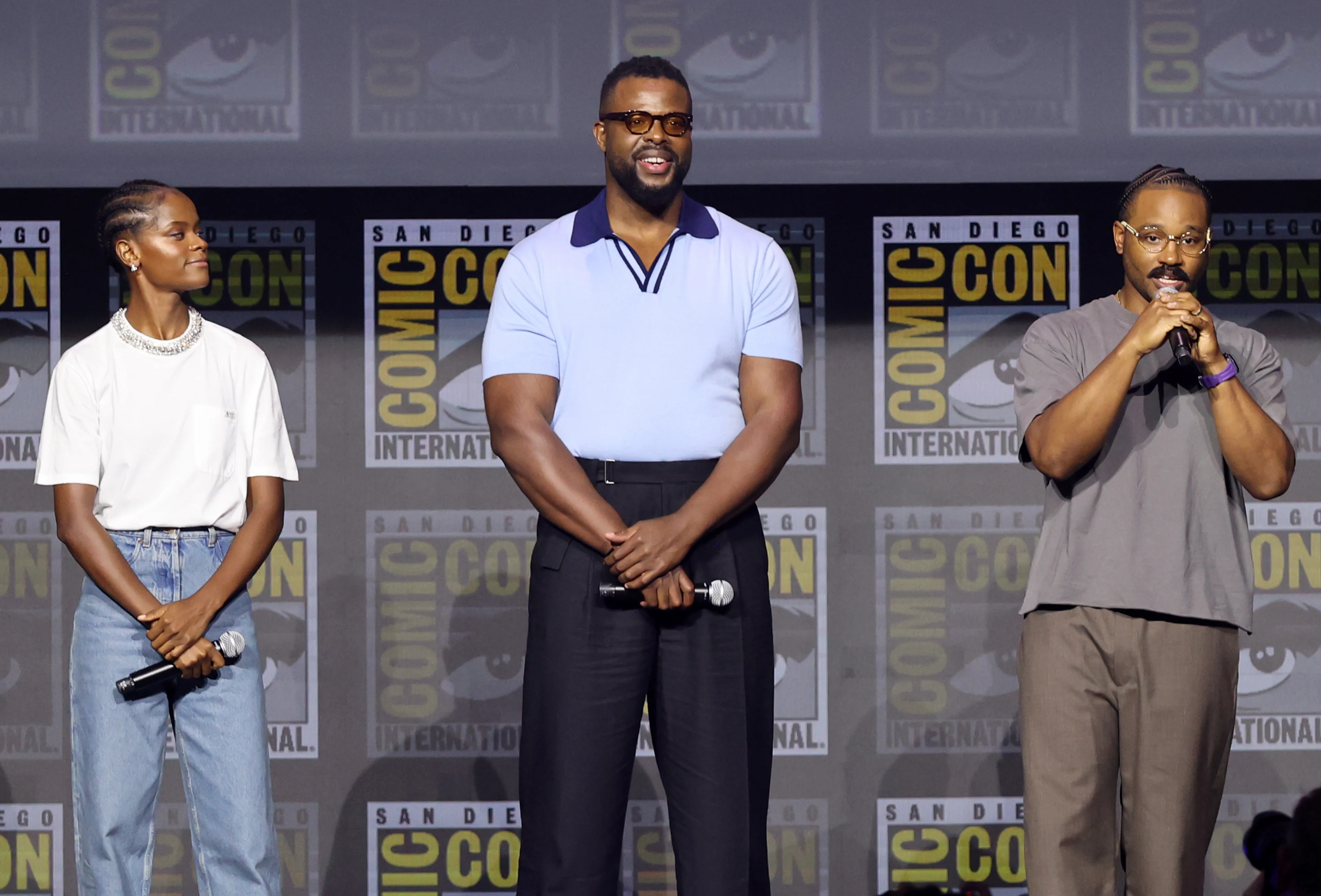 David Jonsson stands between Letitia Wright and director Ryan Coogler during Marvel Studios’ Black Panther 3 presentation.