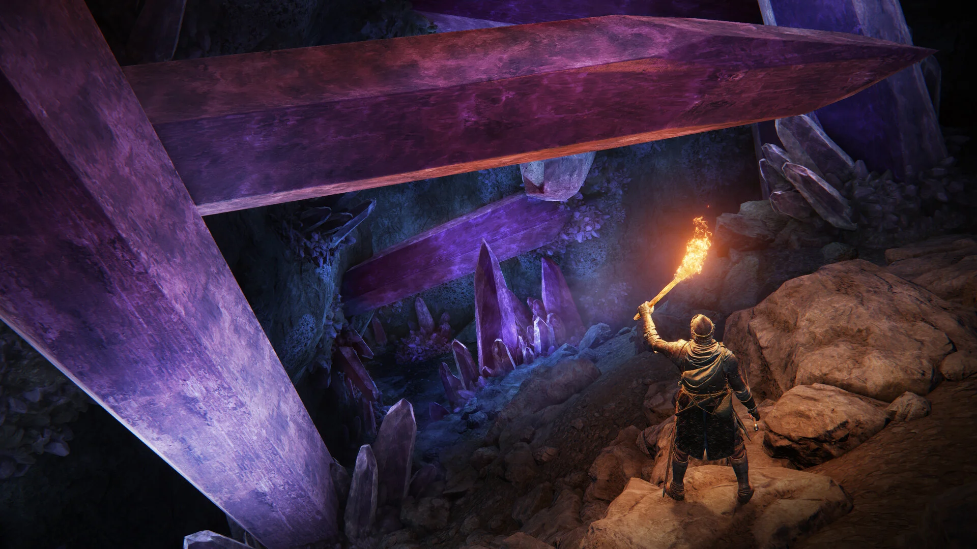 A Tarnished holding a torch explores a cavern filled with giant purple crystals.