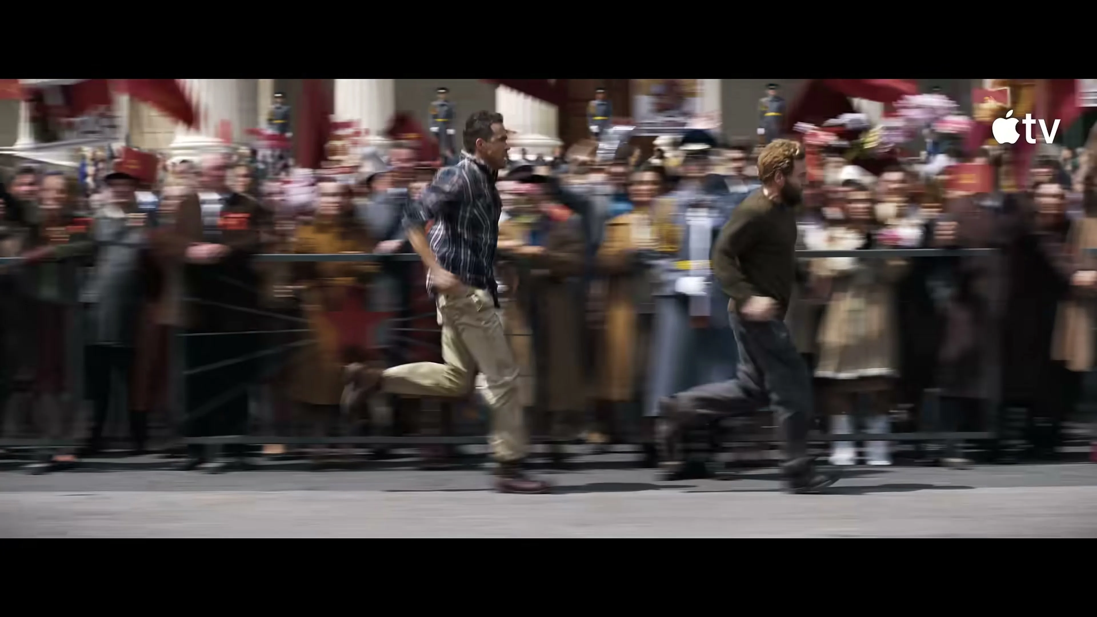 Troy and Nikolai run through a colorful public festival in Mayday.