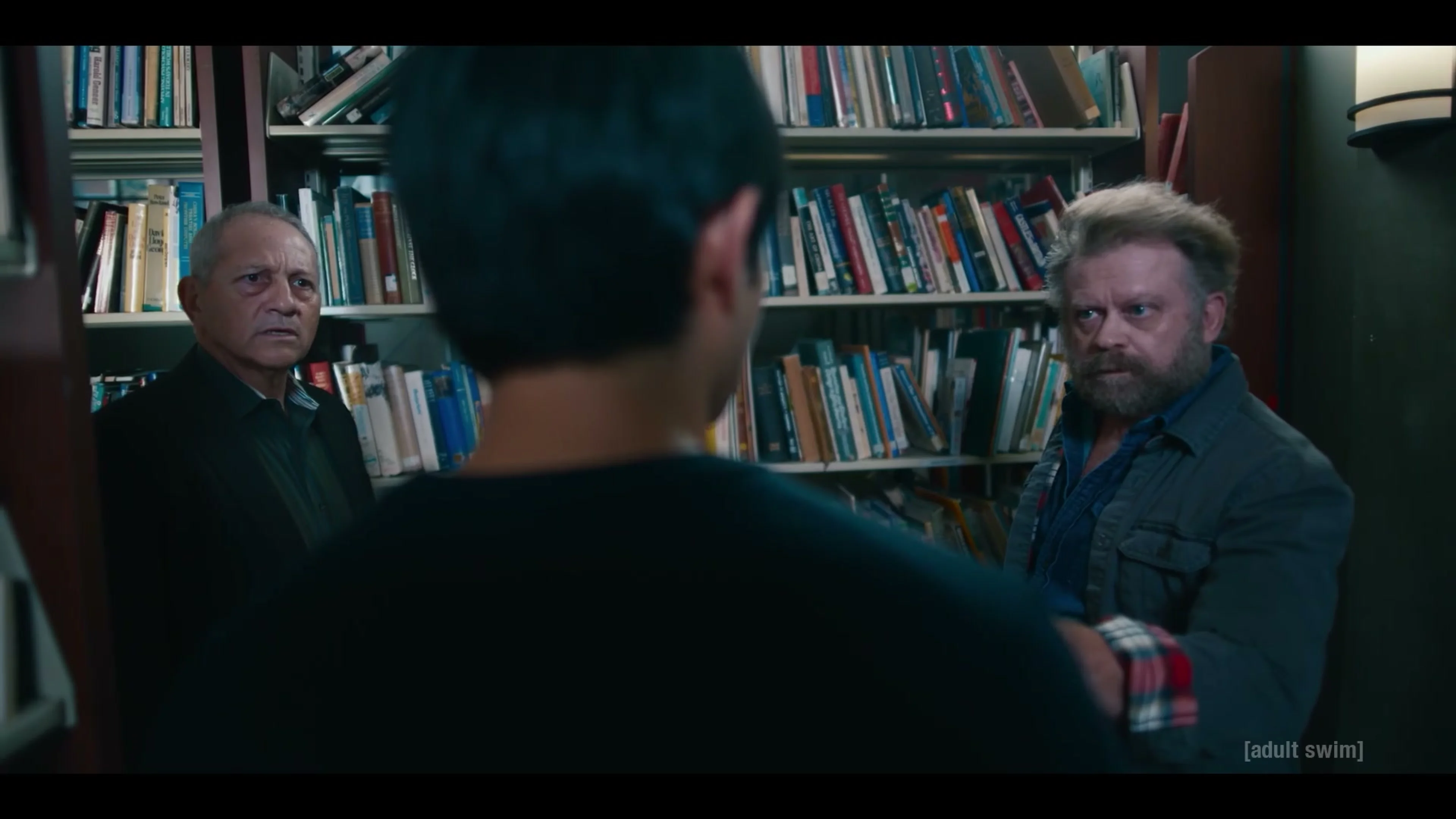 Jordan Mendoza faces two men between library bookshelves in The Terrors of Jordan Mendoza.
