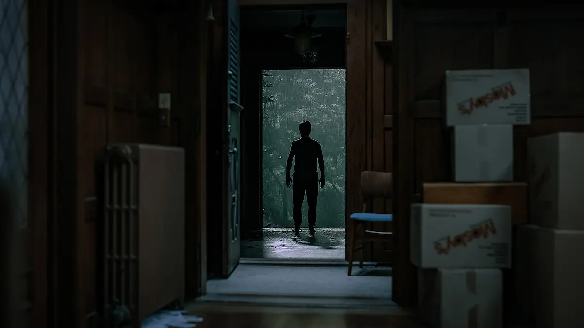 A silhouetted figure stands in the doorway of a house in The Whisper Man.