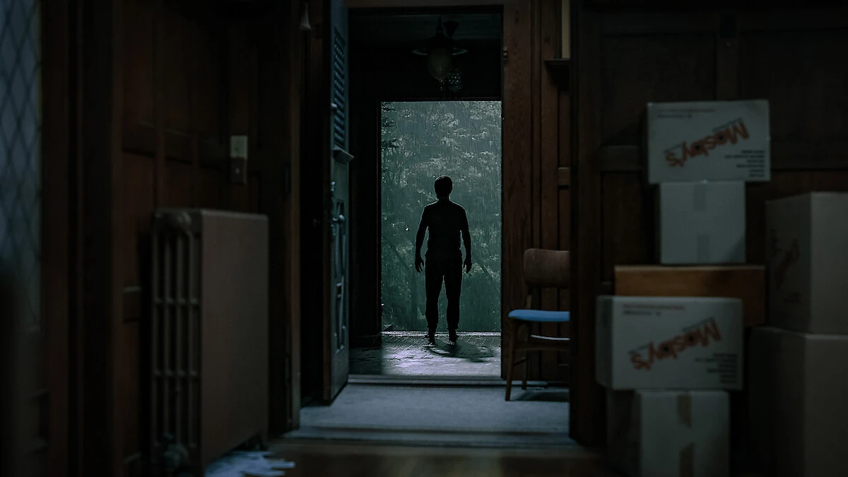 A silhouetted figure stands in the doorway of a house in The Whisper Man.