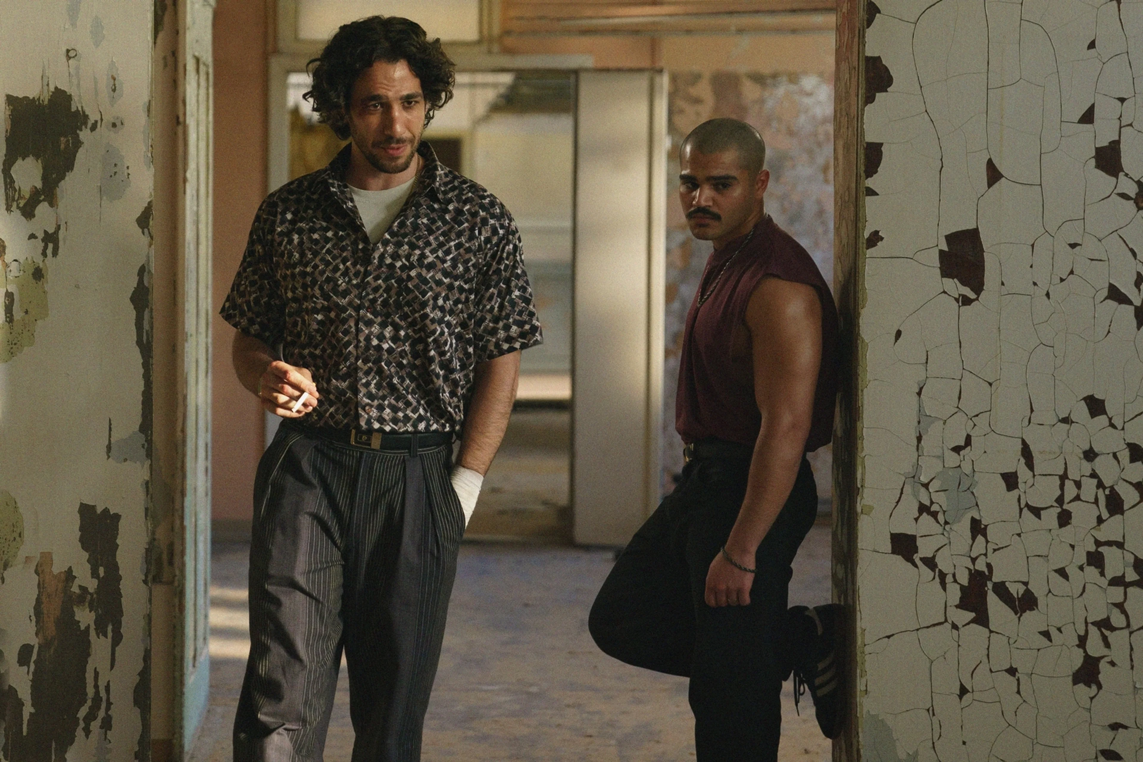 Two men stand inside a damaged industrial building in a scene from 4 Blocks Zero Episode 6.