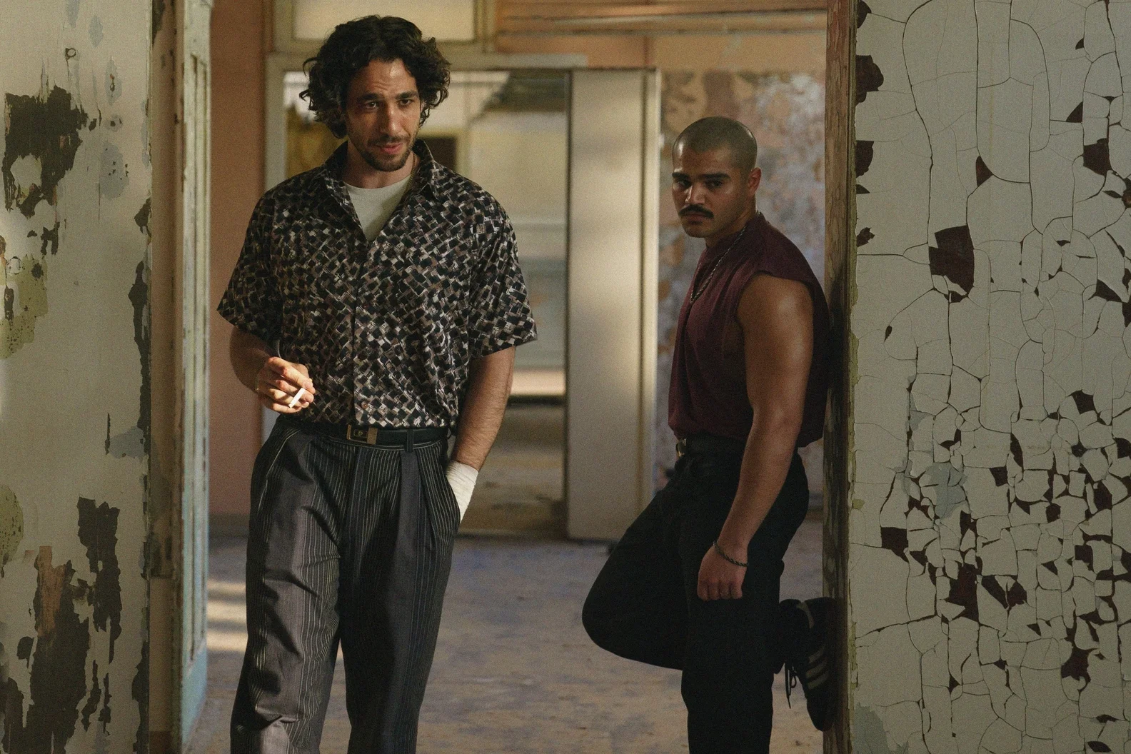 Two men stand inside a damaged industrial building in a scene from 4 Blocks Zero Episode 6.