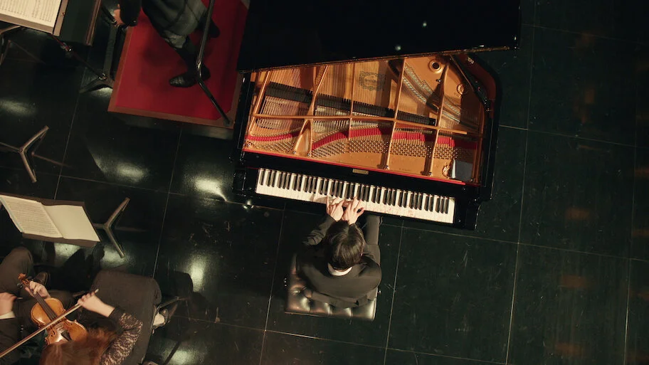 A student pianist performs with an orchestra in Four Hands, Two Sonatas.