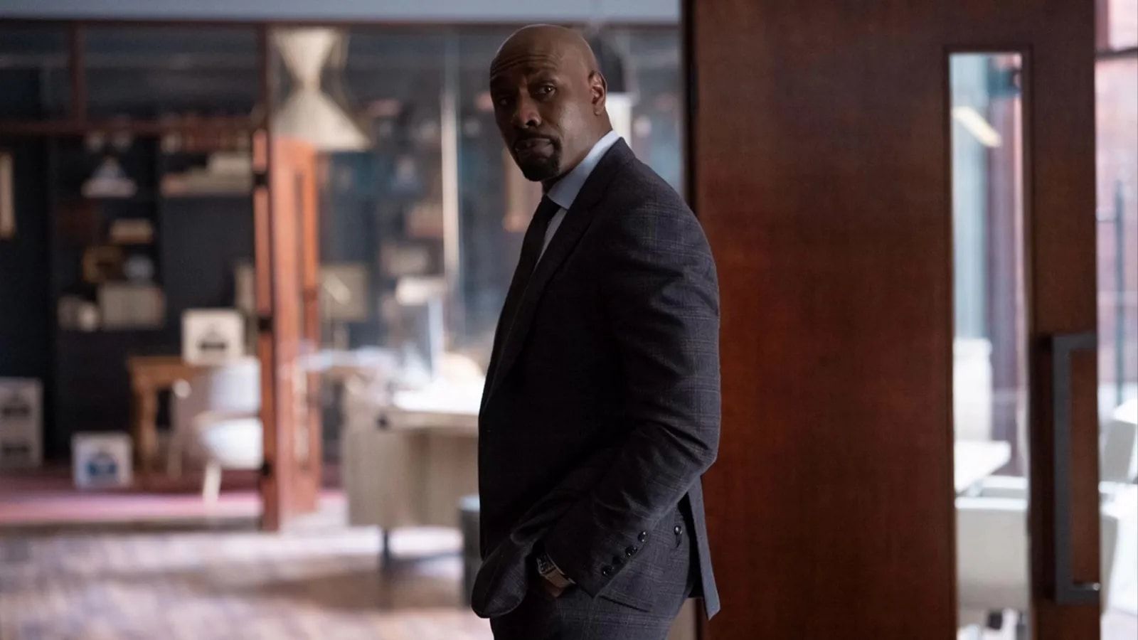 Morris Chestnut as attorney Corey Cash stands in an office.