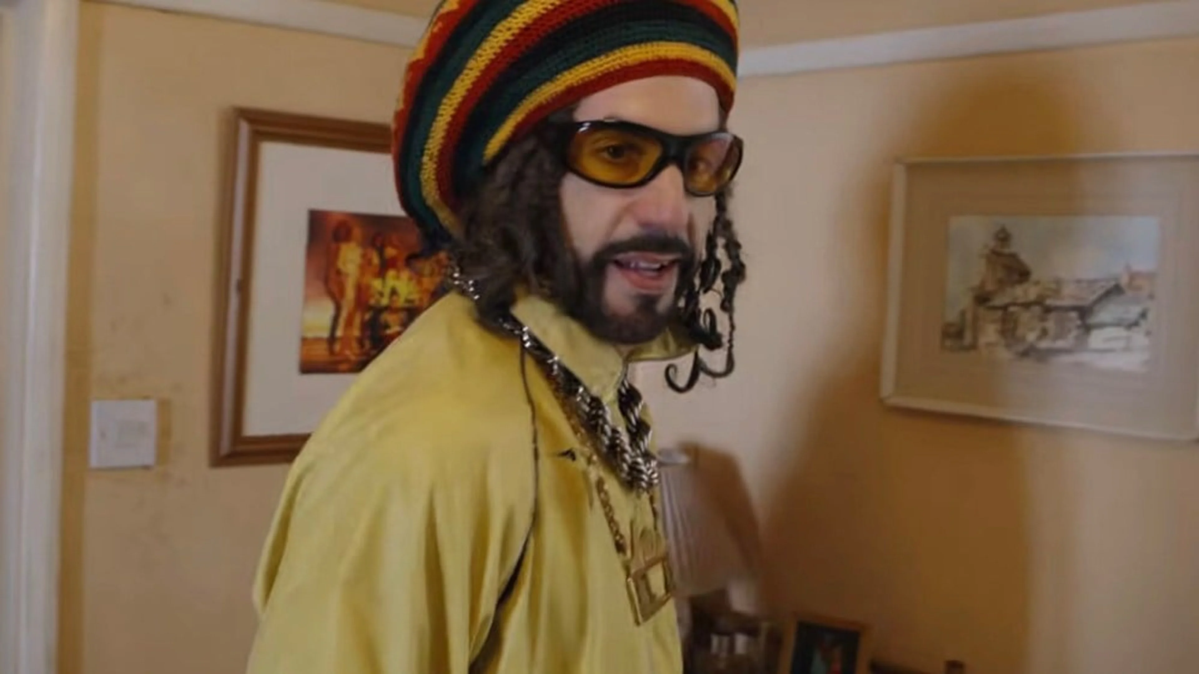 Sacha Baron Cohen appears as Ali G in a yellow outfit and striped hat in a scene from Ali G: Who Iz I?.