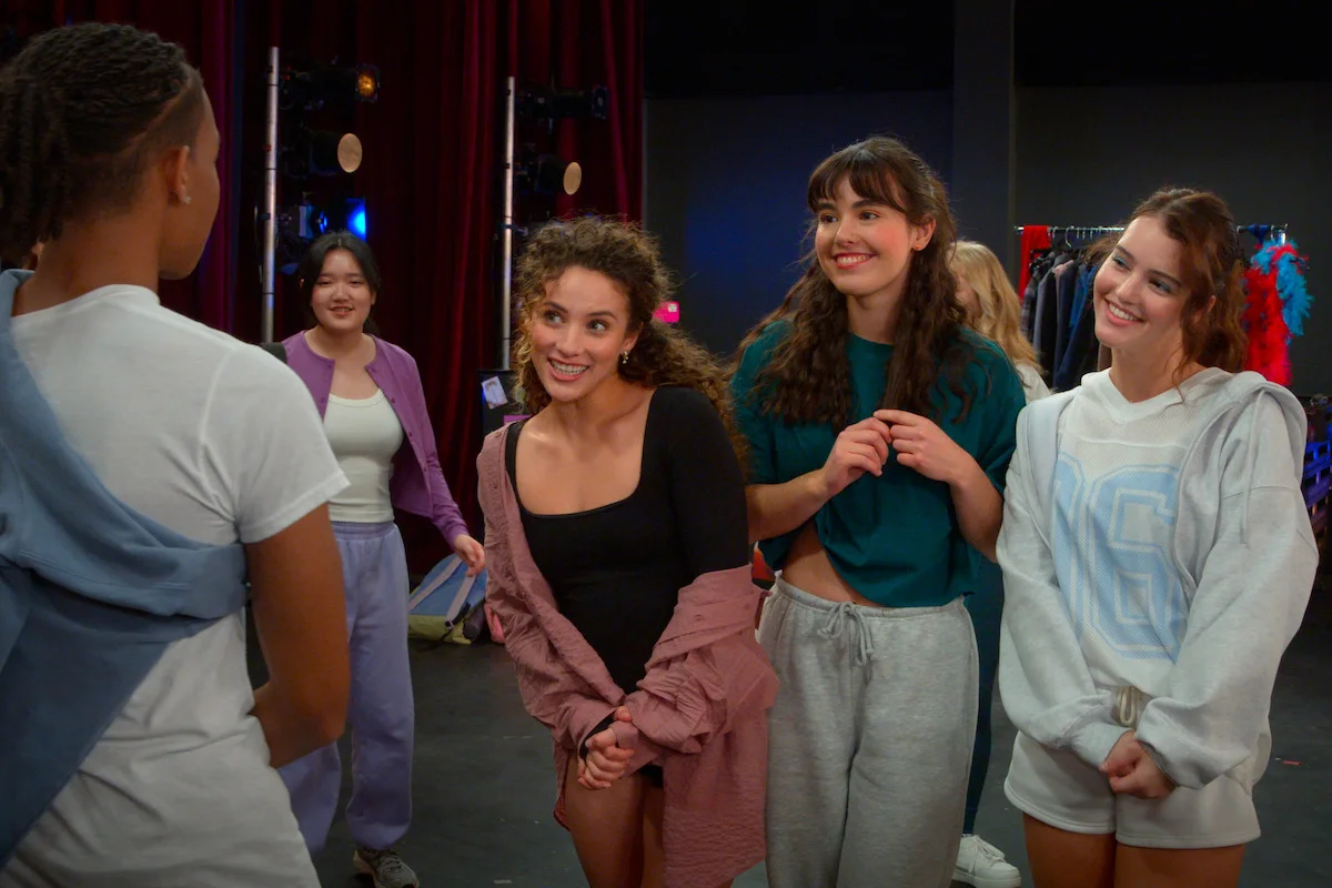 Four Hollywood Arts students talk backstage during a rehearsal.