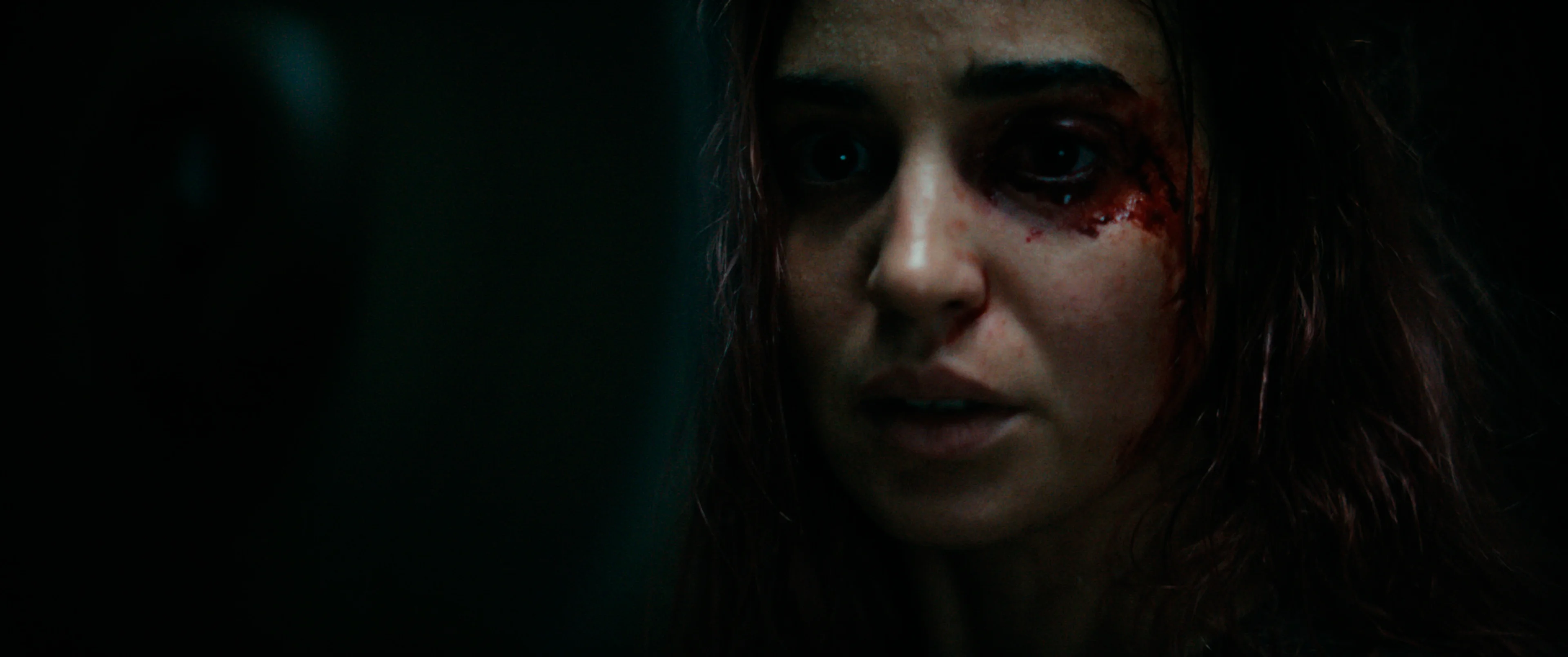 A woman in Evil Dead Burn looks toward the camera.