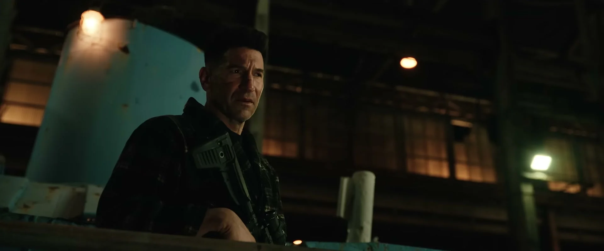 Jon Bernthal as Frank Castle holds a gun and looks across a room in Brand New Day.