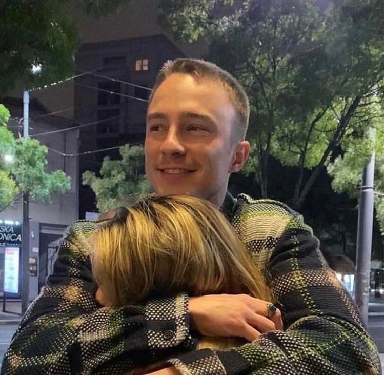 Drew Starkey smiles outdoors at night.