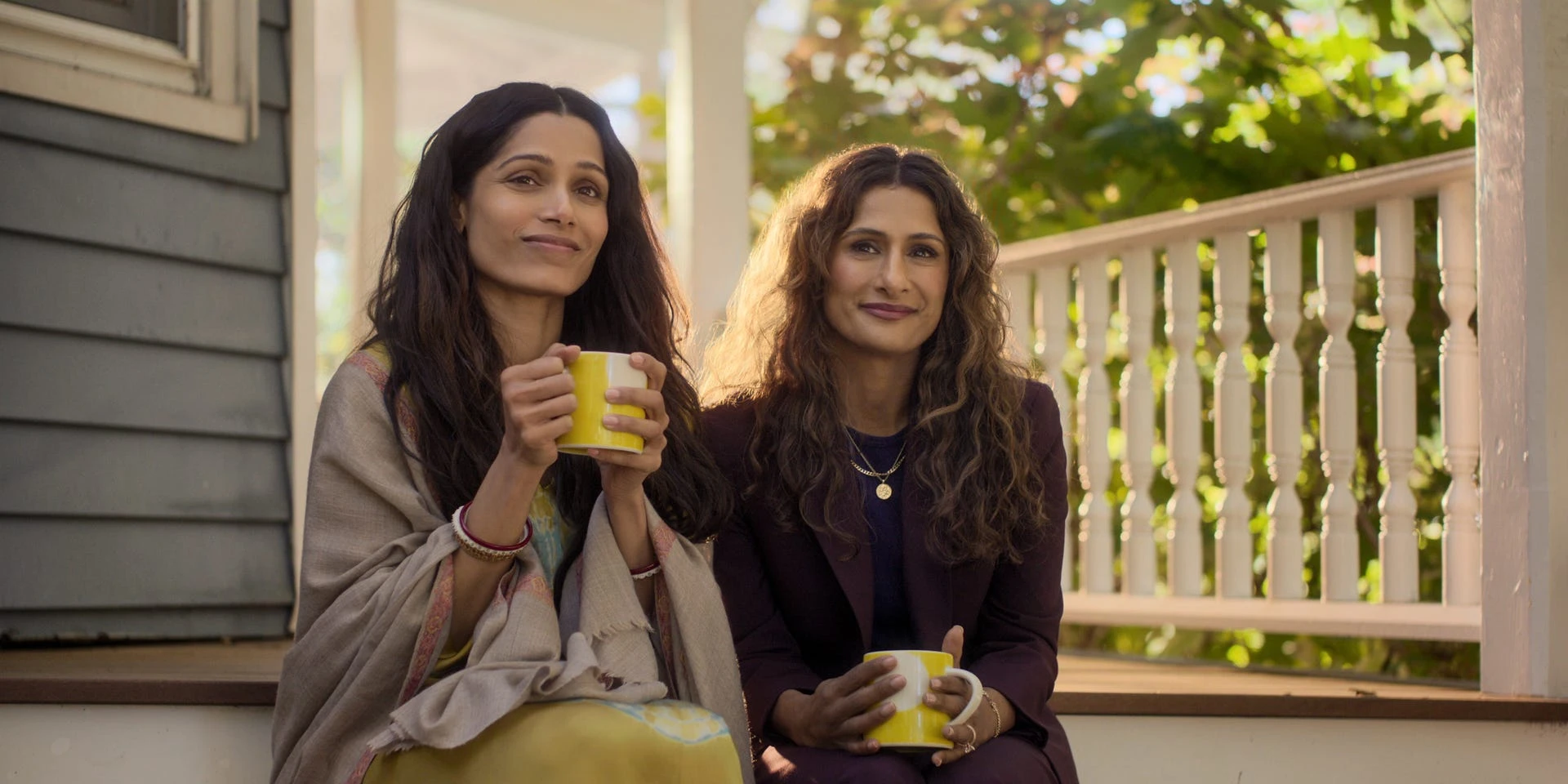 Freida Pinto and Sarayu Blue sit together in sunlight on a porch in Unaccustomed Earth.