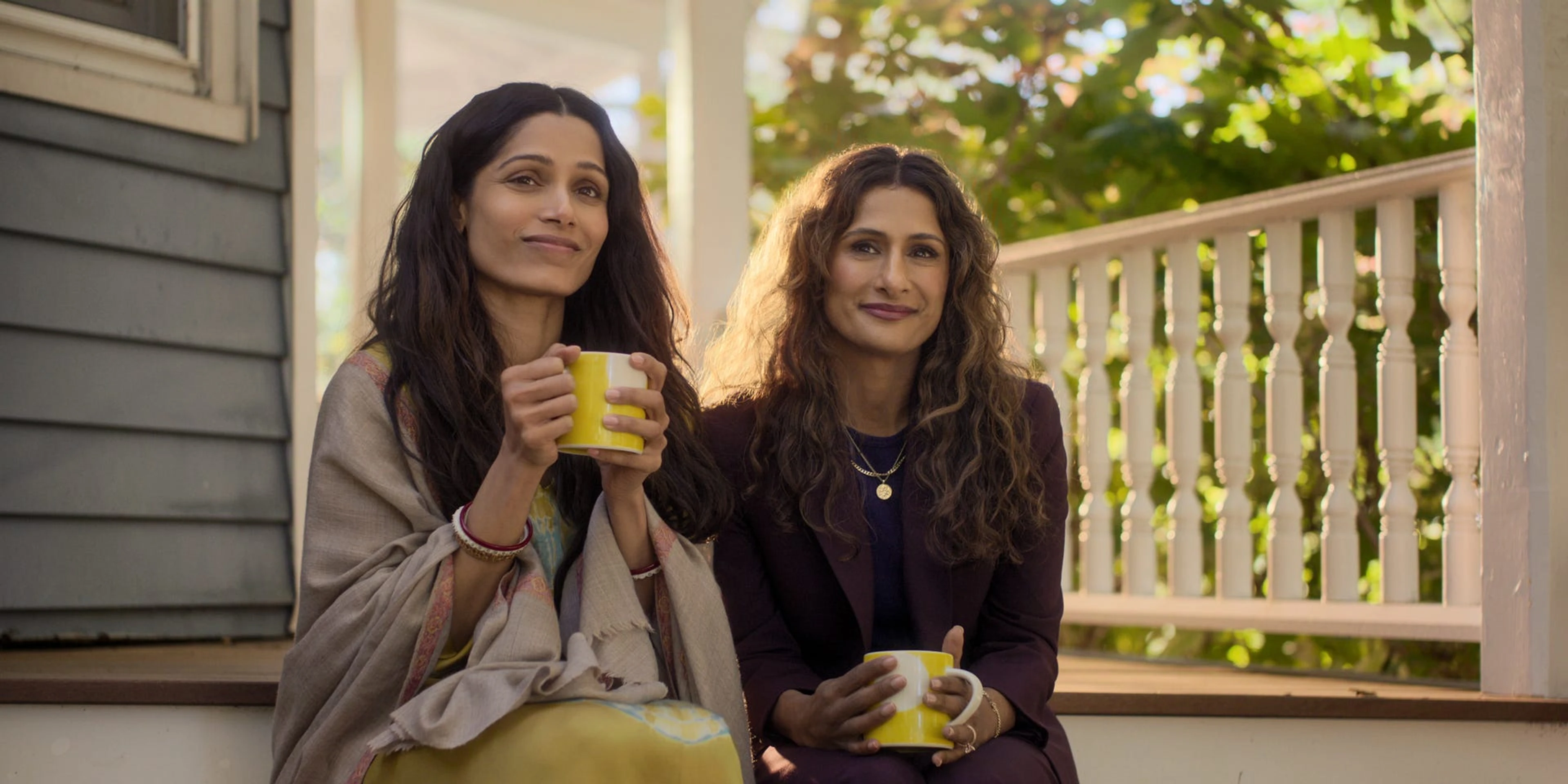 Freida Pinto and Sarayu Blue sit together in sunlight on a porch in Unaccustomed Earth.