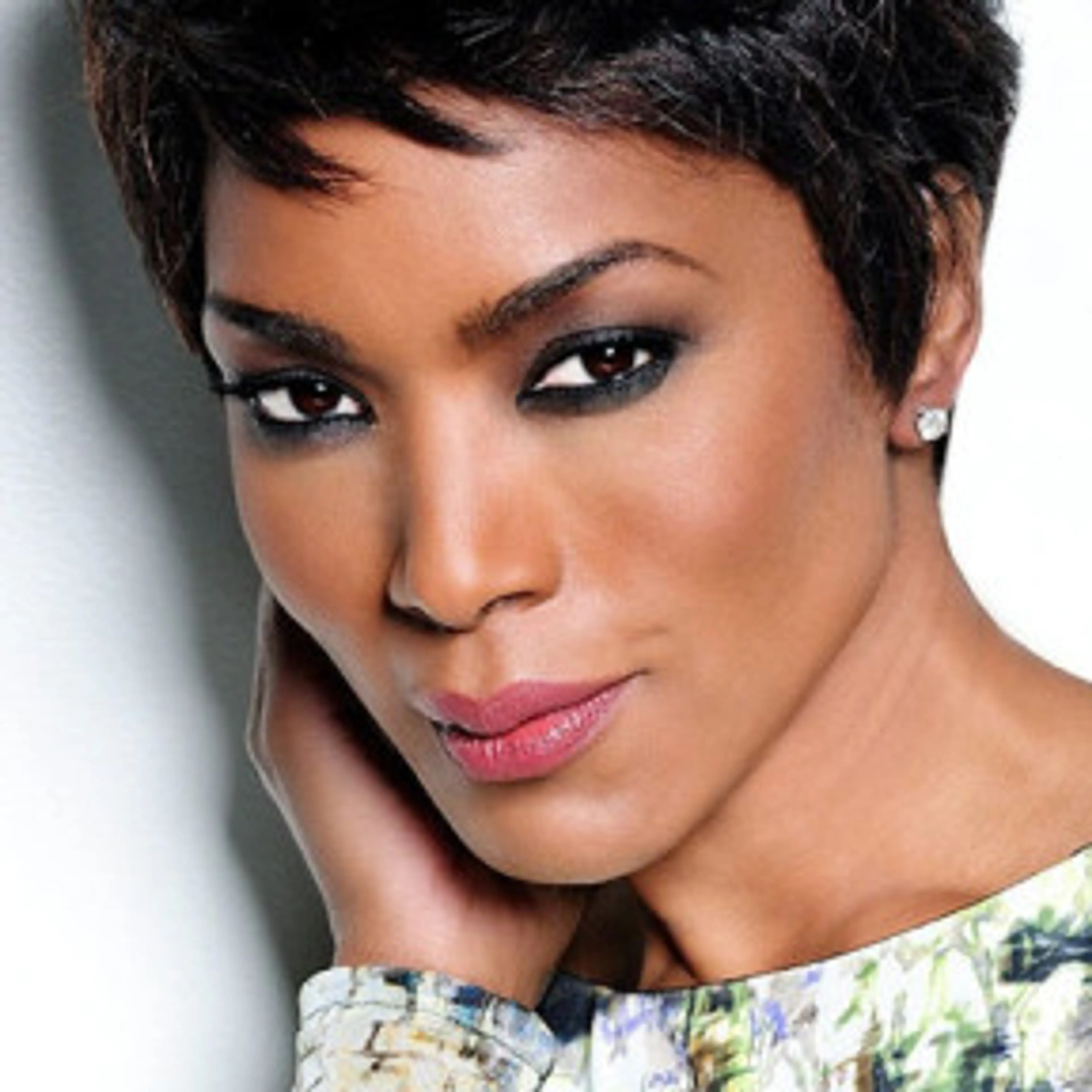 Portrait of Angela Bassett with short dark hair and a patterned top.
