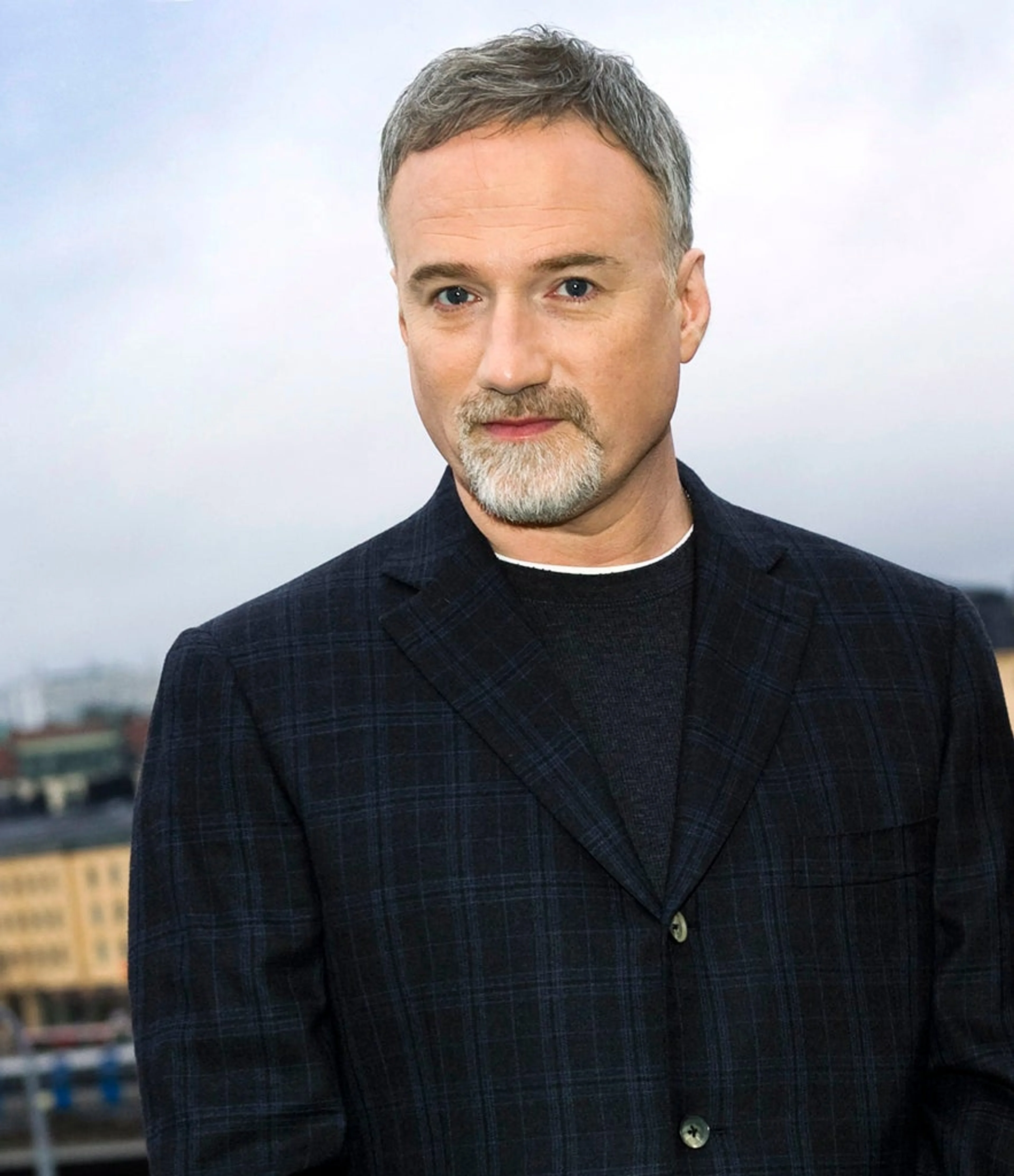 David Fincher looks toward the camera in a contextual portrait.