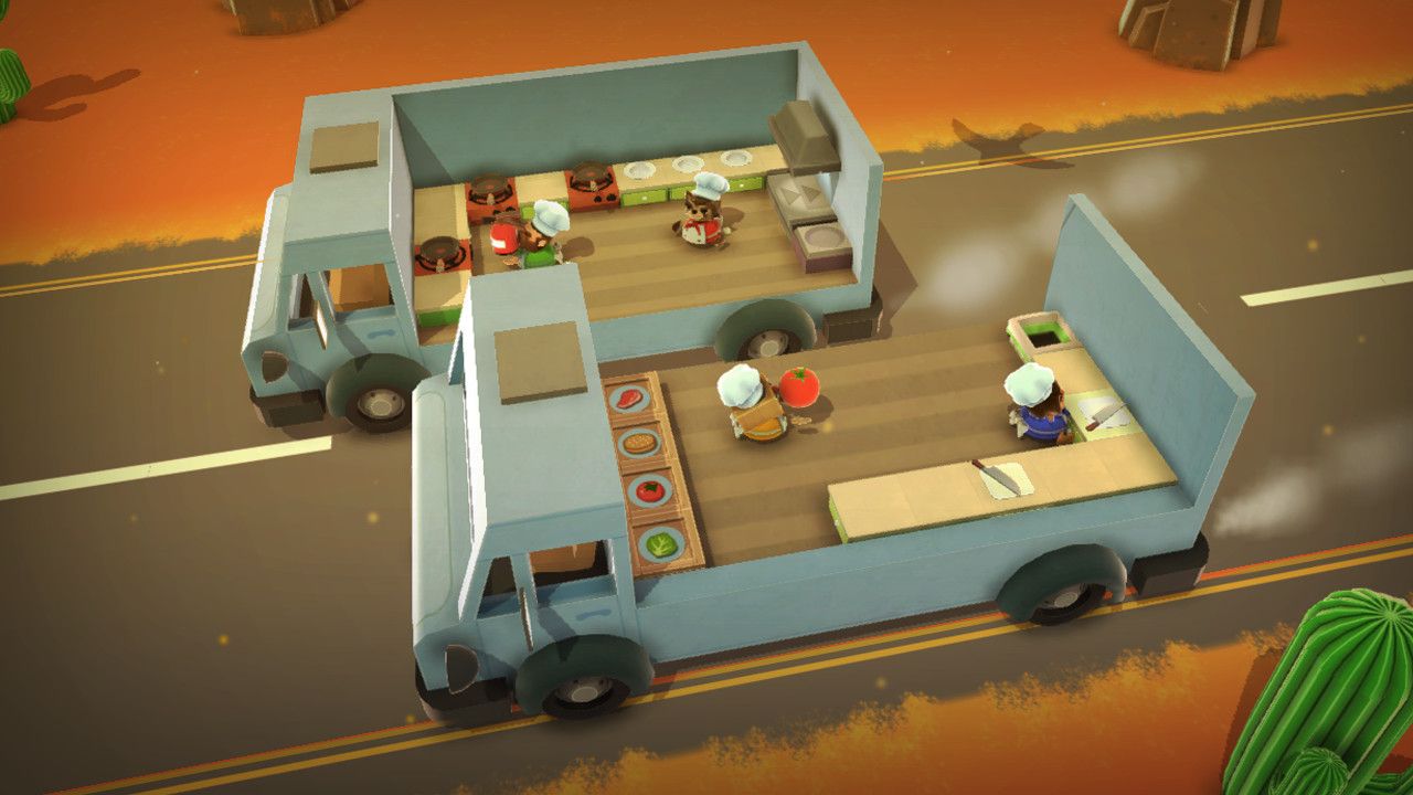 Two moving trucks each carry part of a kitchen while chefs work between them.