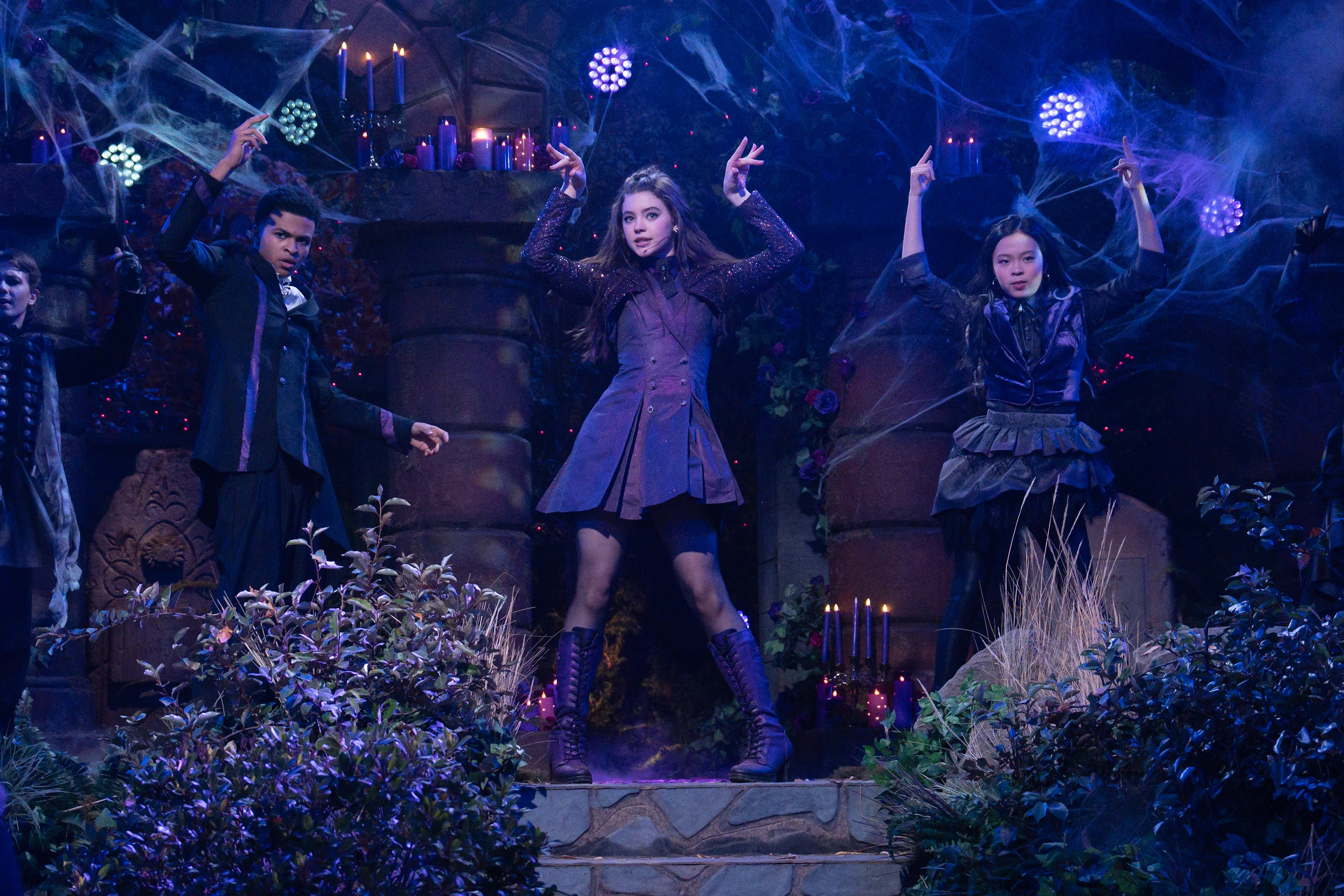 Shaun Dixon as Elijah, Kenzi Richardson as Vee, and Jiwon Lee as Sophie perform on a blue-lit supernatural stage in Vampirina: Teenage Vampire Season 2.