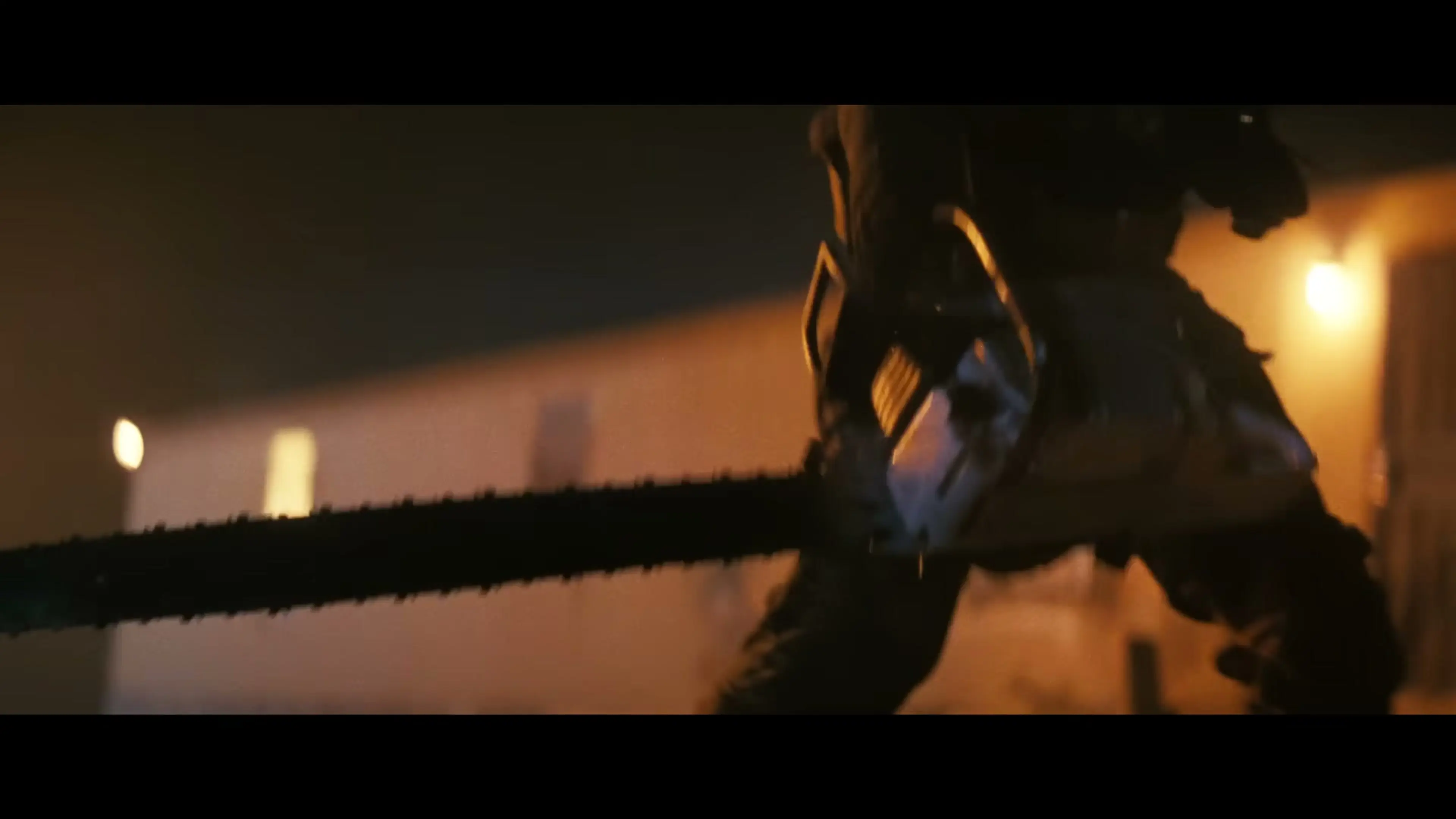 A figure raises a chainsaw during a night fight in Onslaught.