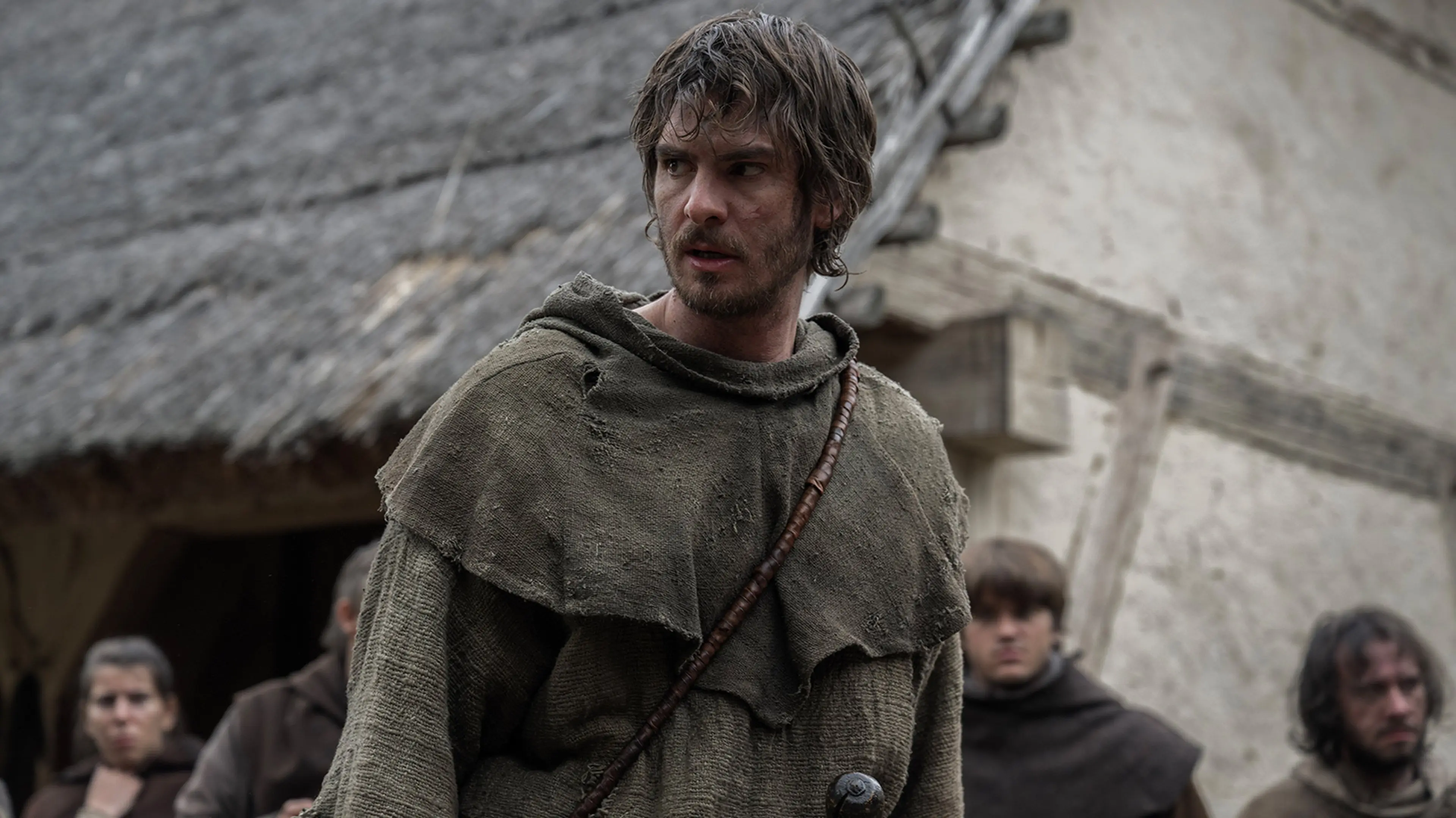 Andrew Garfield as Ploughman stands in a medieval village in The Uprising.